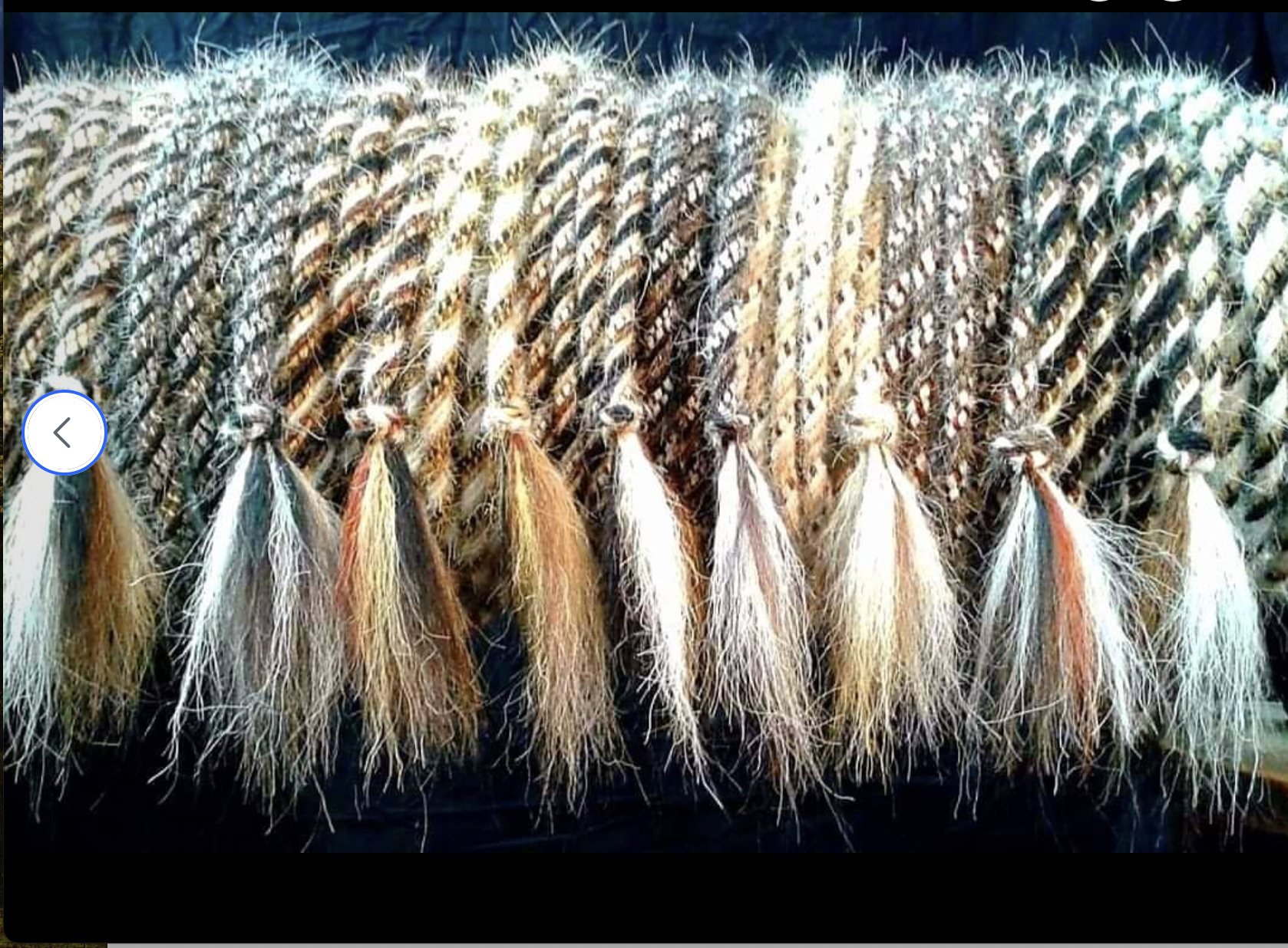 Close-up of colorful, braided plant fibers with dangling feathery tips at the bottom.