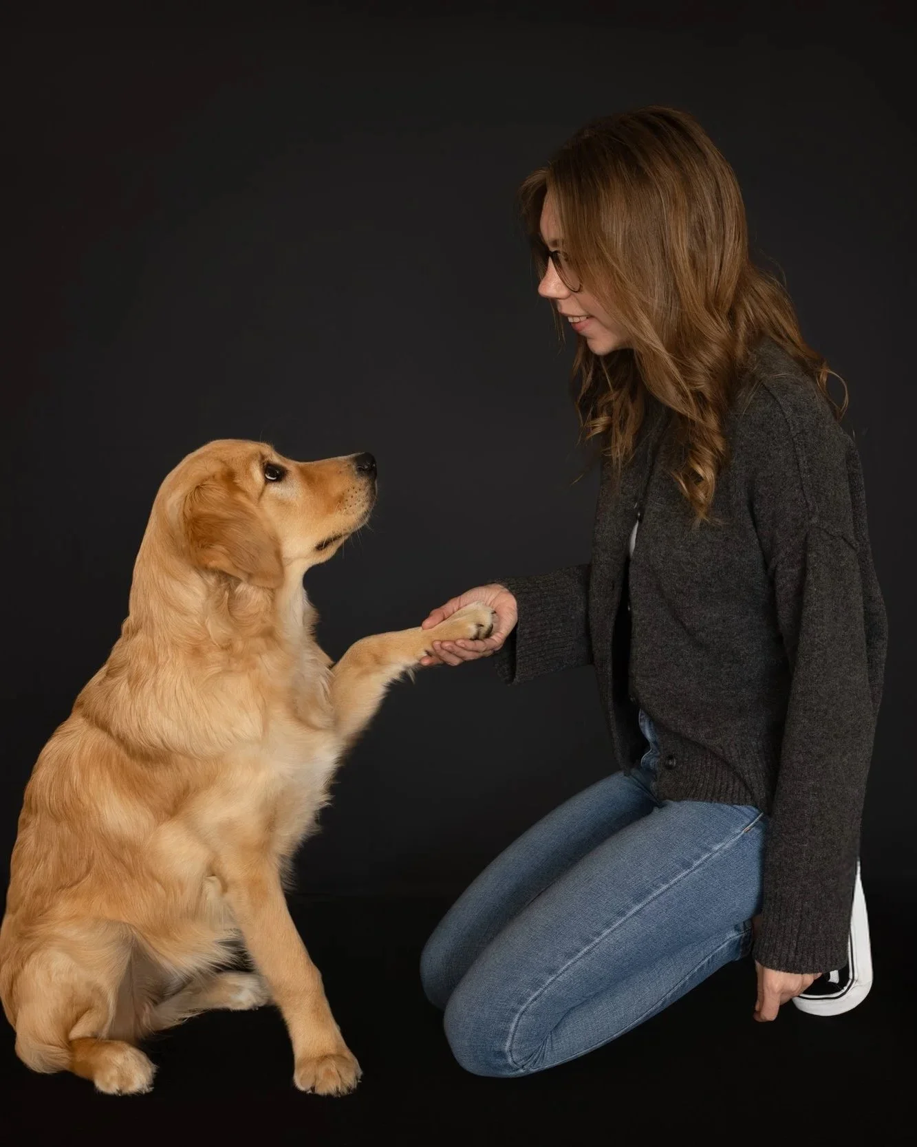 Frau hält Pfote von Golden Retriever