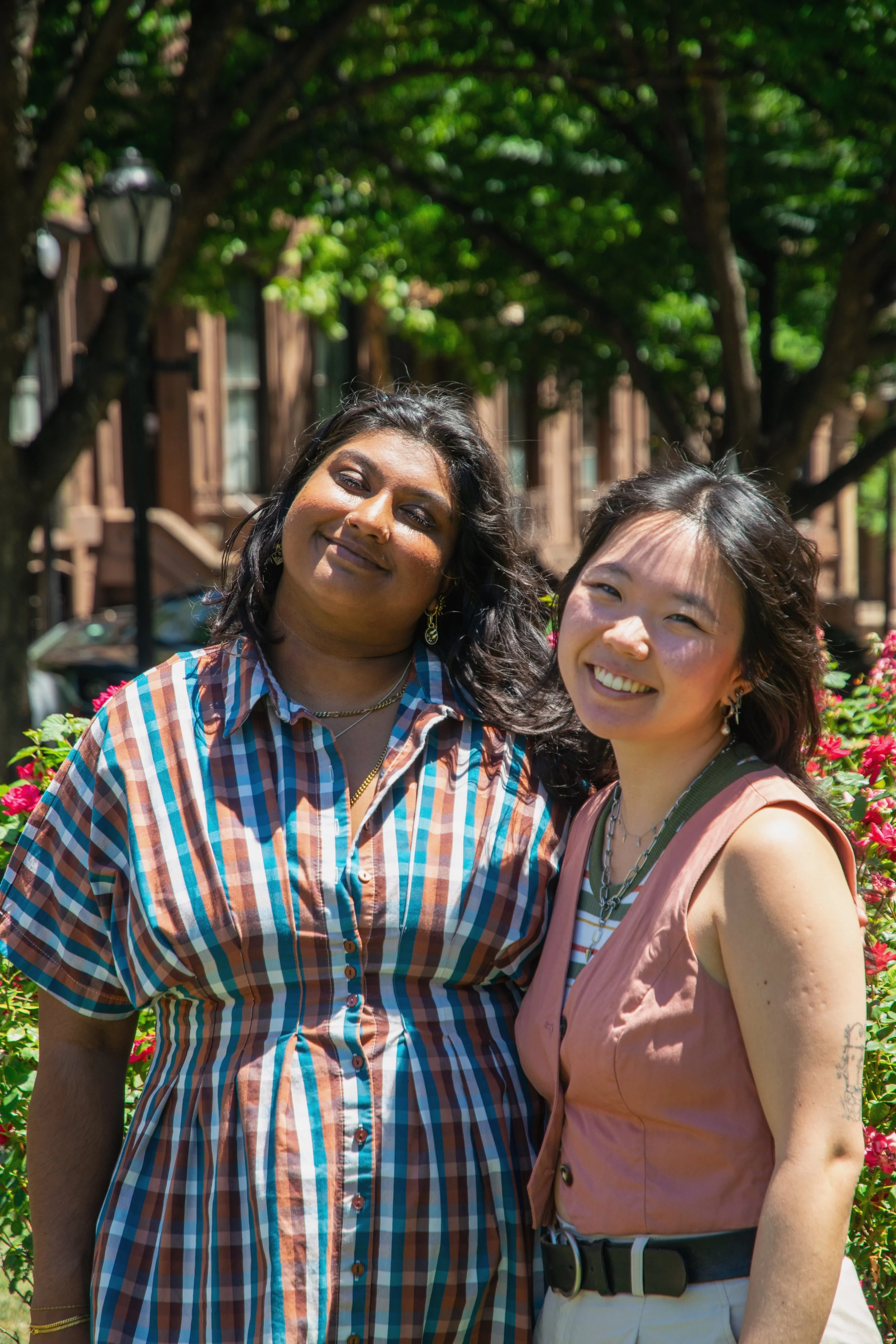 Two Queer and Asian, affirming psycho-therapists in Baltimore, Maryland standing outside and smiling.