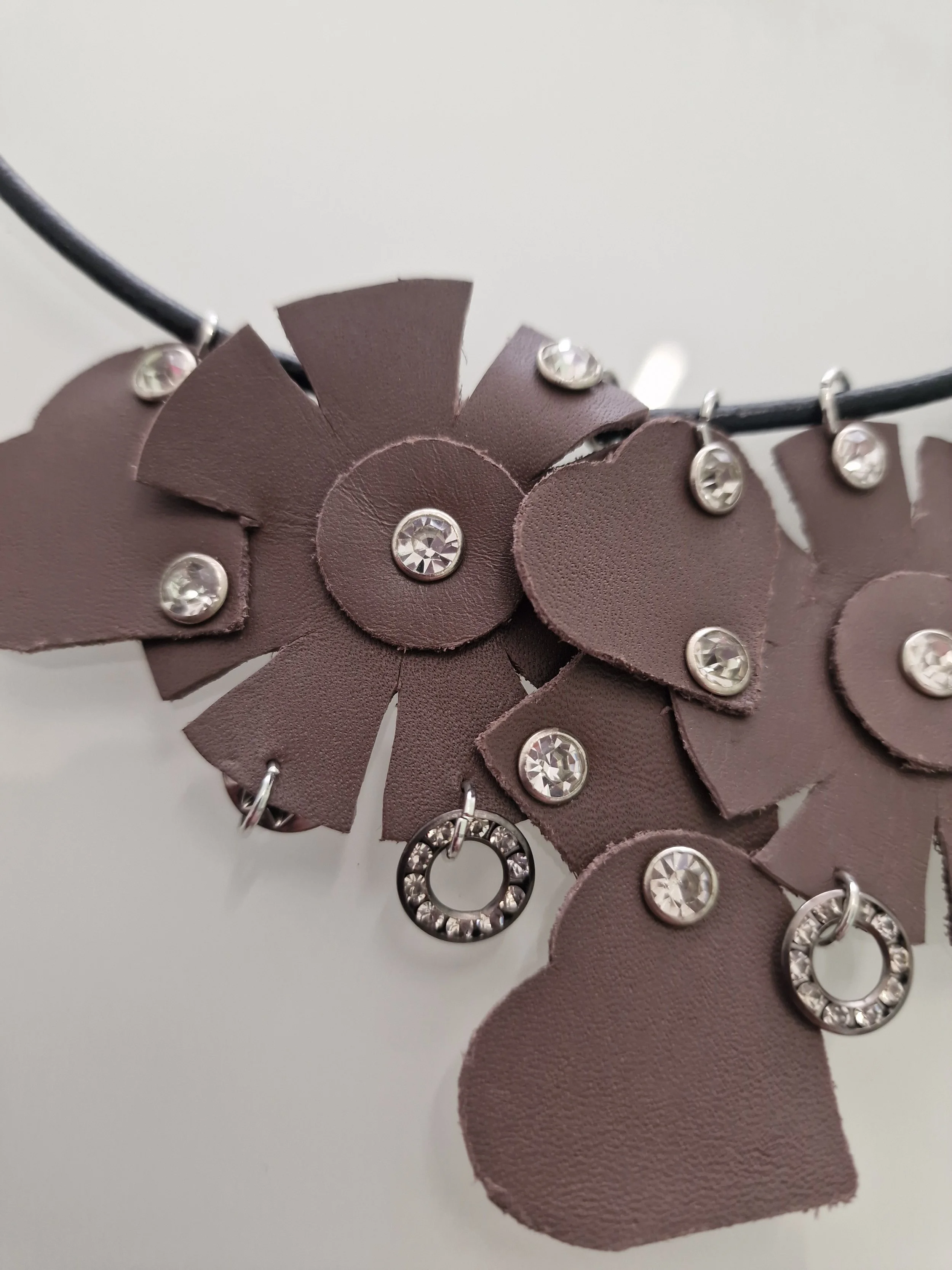 rimo piano del design: fiori e cuore in pelle con anellini e strass luminosi.