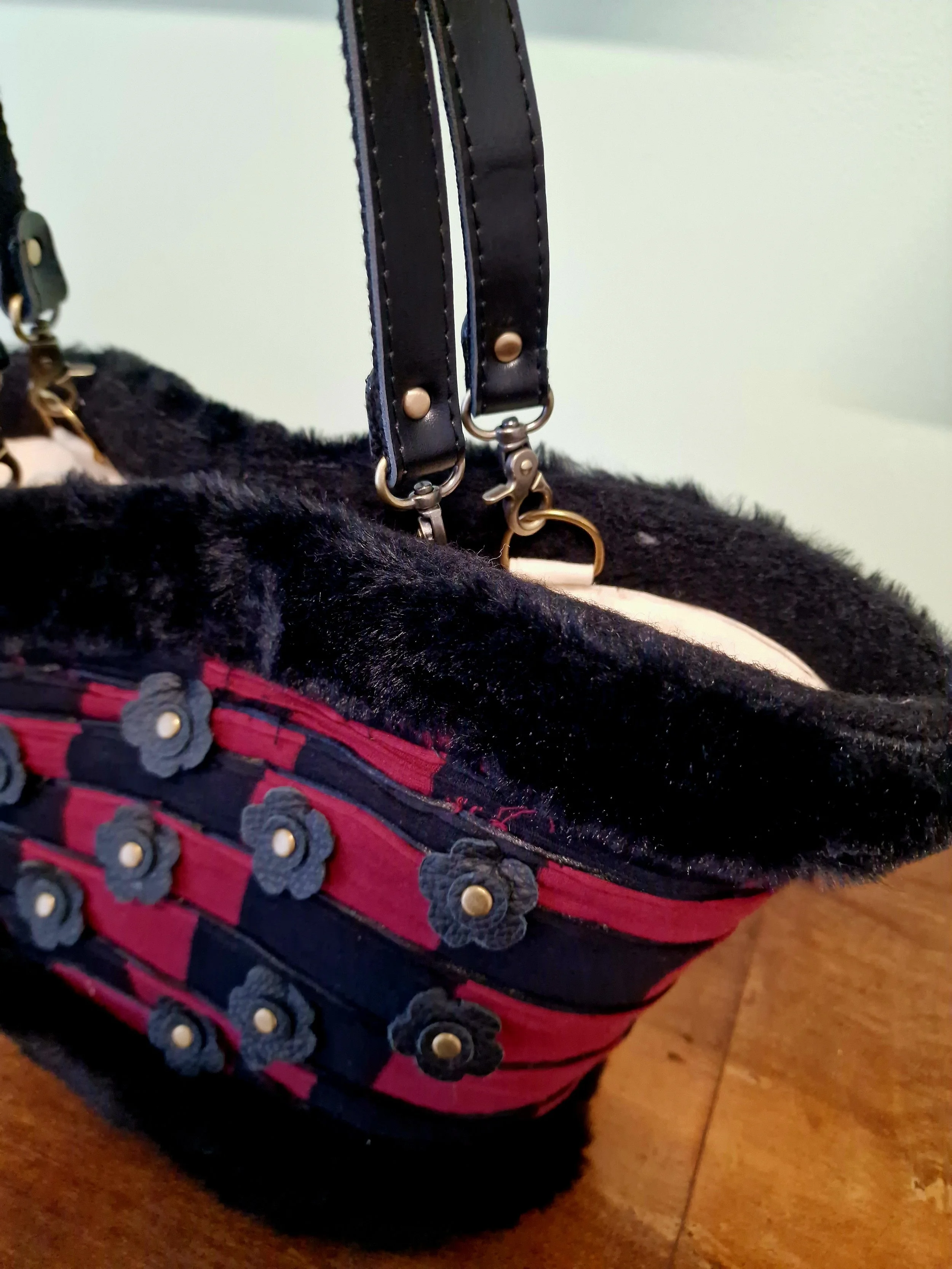 Dettaglio fiori in pelle con borchie e base in pelliccia della borsa Elison, artigianato siciliano couture