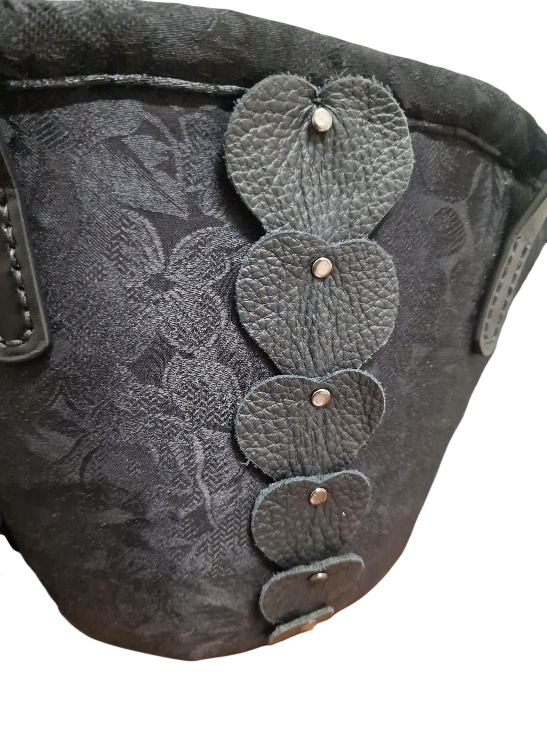 Dettaglio cuori in pelle applicati sulla coffetta Etna Ammuri in seta damascata nera