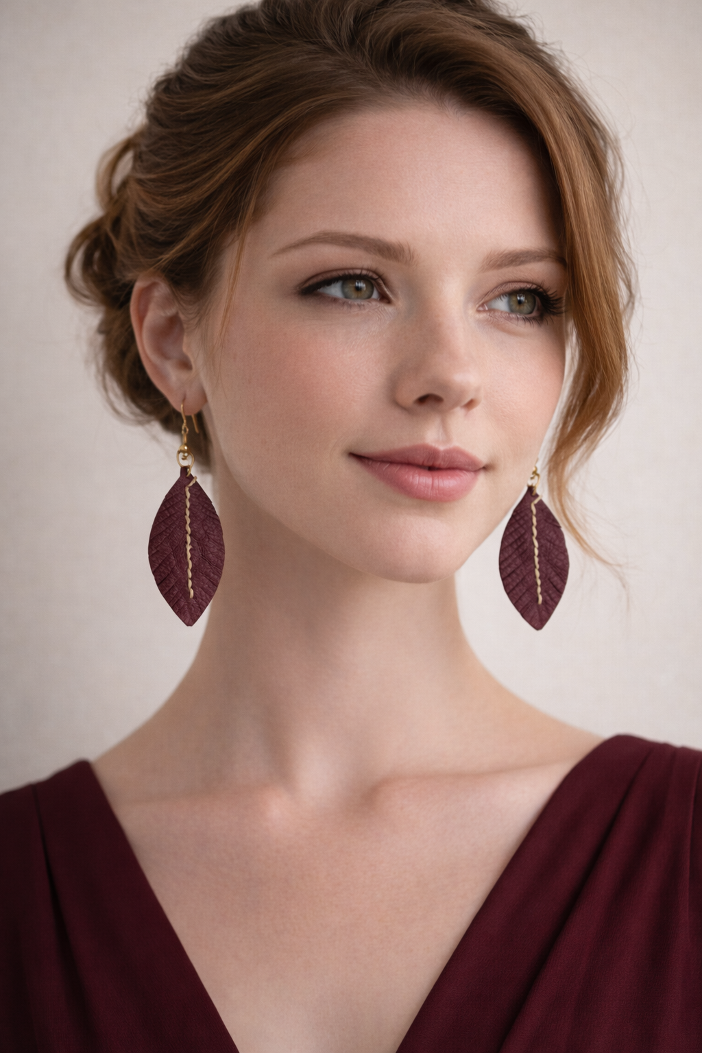 Orecchini Fronda in pelle bordeaux indossati, bijou artigianali fatti a mano