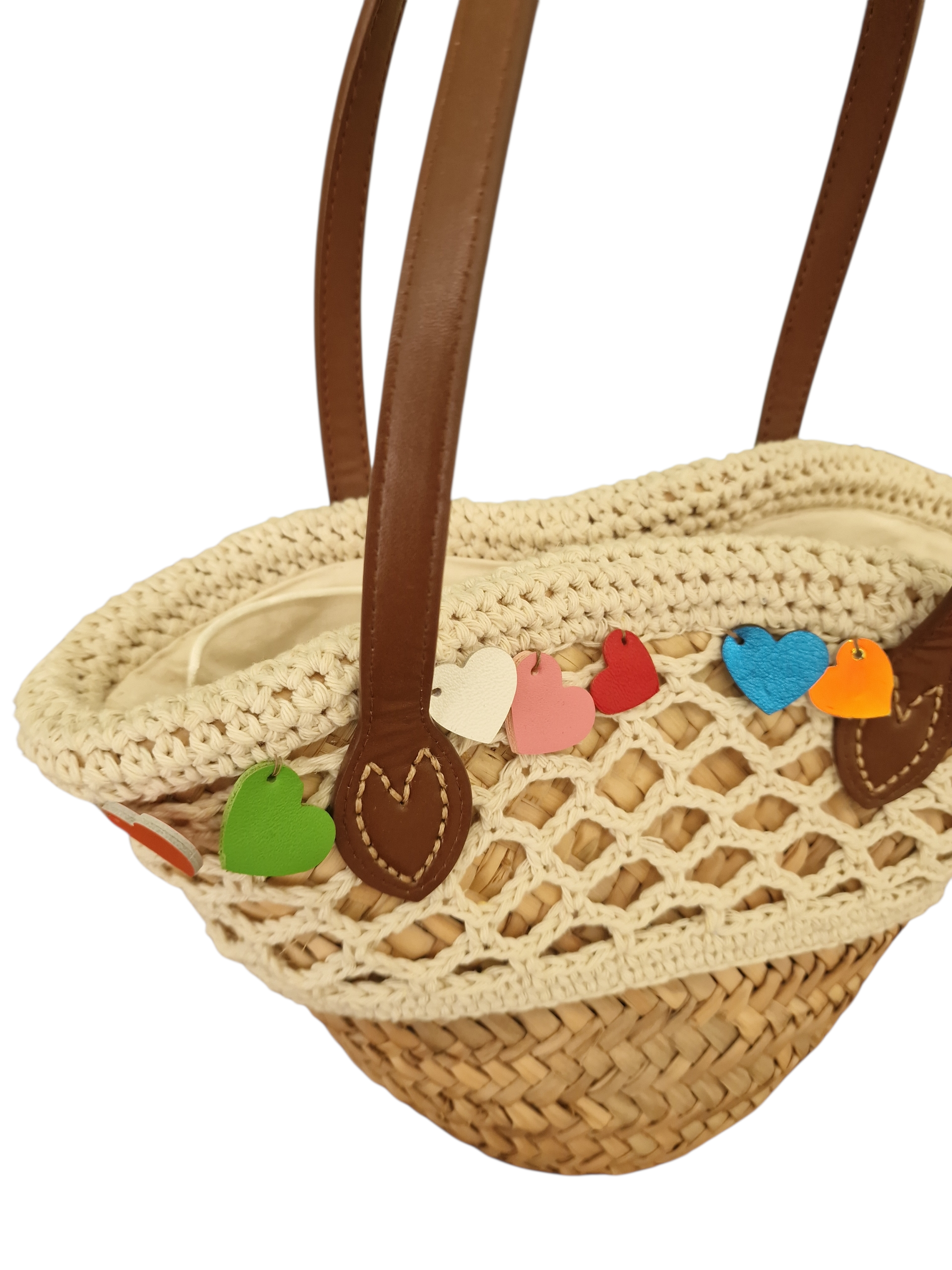 vista da vicino dei cuori in pelle colorata applicati sul bordo supeeriore della borsa , fatti a mano in vera pelle