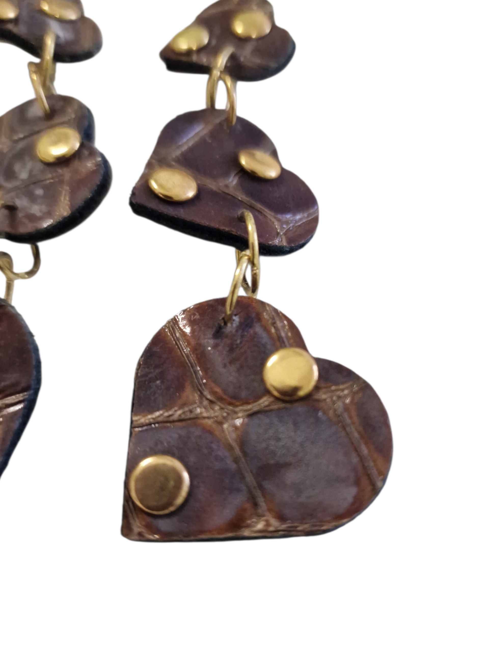 Dettaglio orecchini pendenti con cuori in pelle effetto cocco marrone e borchiette dorate Ammuri Sicilia