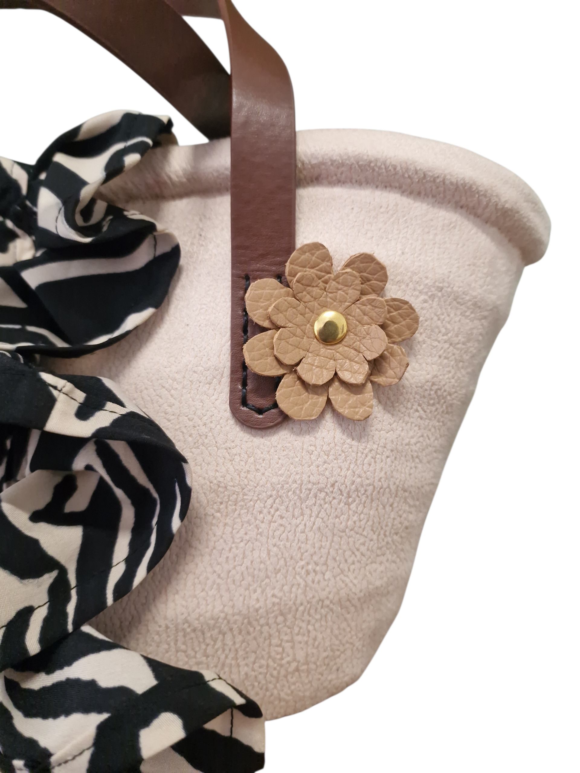 Dettaglio laterale coffa Ammuri bianco panna con applicazione fiore in pelle e tessuto blu fantasia, finiture eleganti.