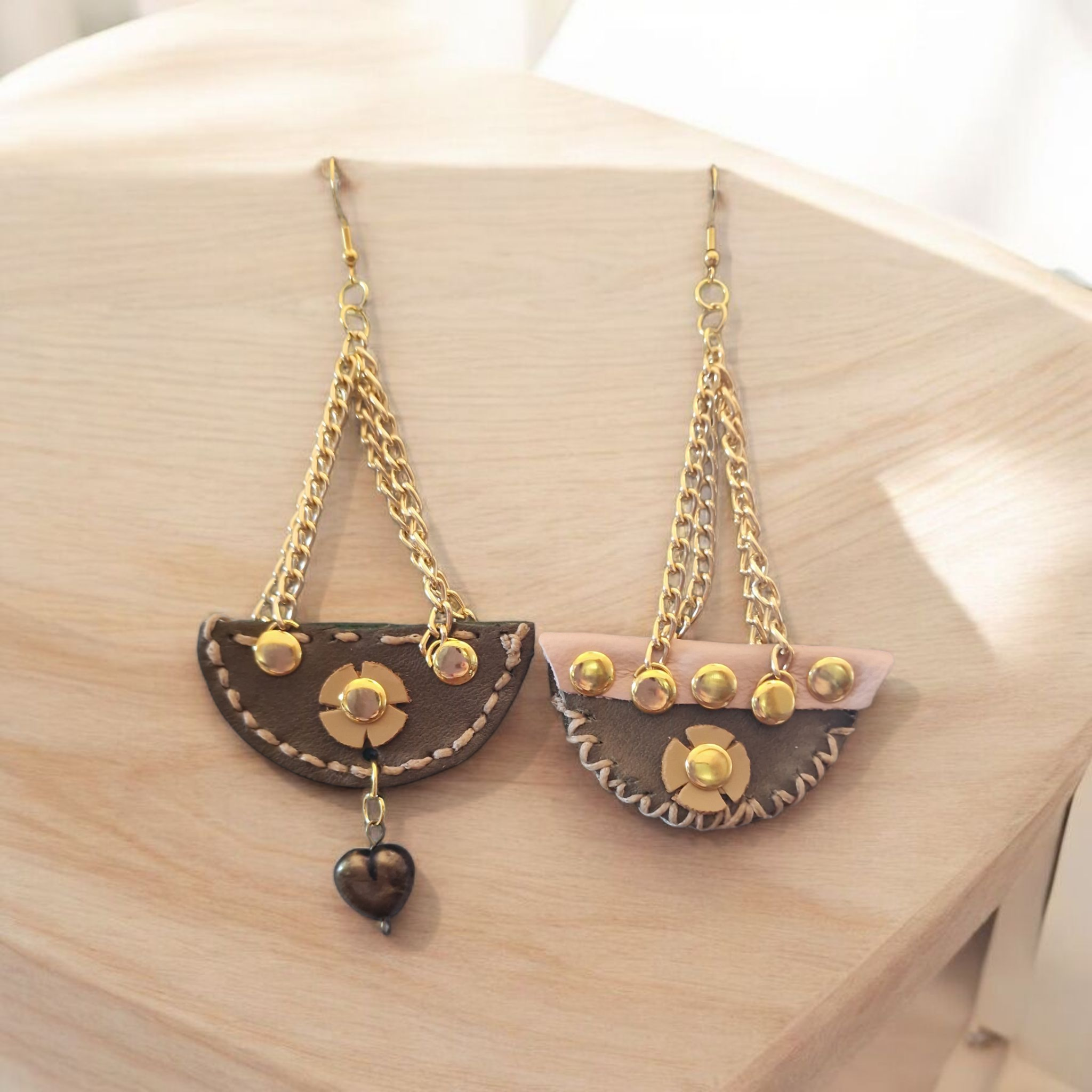 Orecchini artigianali Ammuri “Cuore di Sicilia” in pelle marrone e oro, con catena dorata e cuore pendente, realizzati in Sicilia.