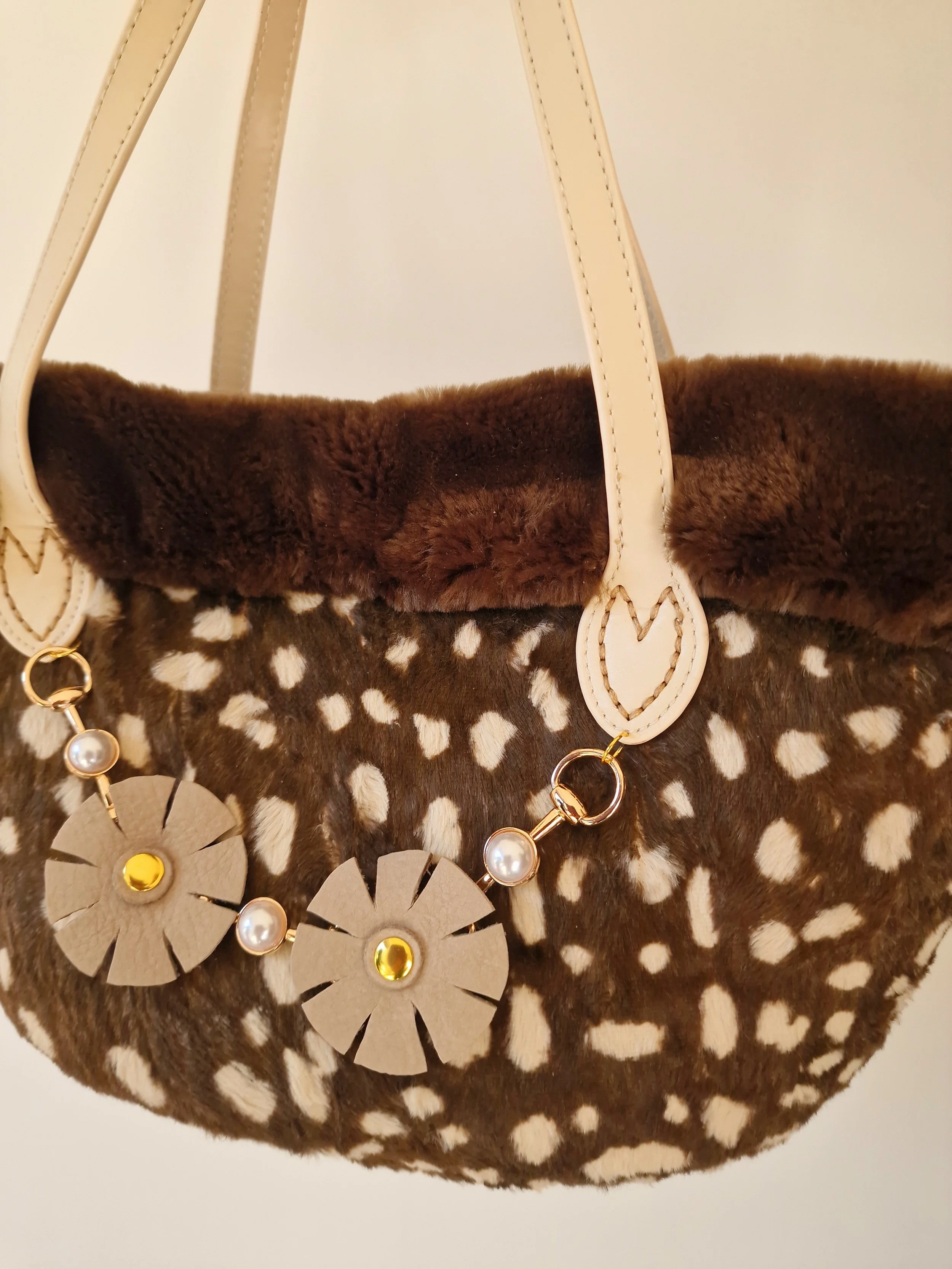 Dettaglio della coffa “Terra Viva” Ammuri Sicilia con manici in pelle e bordo in eco-pelliccia, decorata con fiori in pelle e perle.