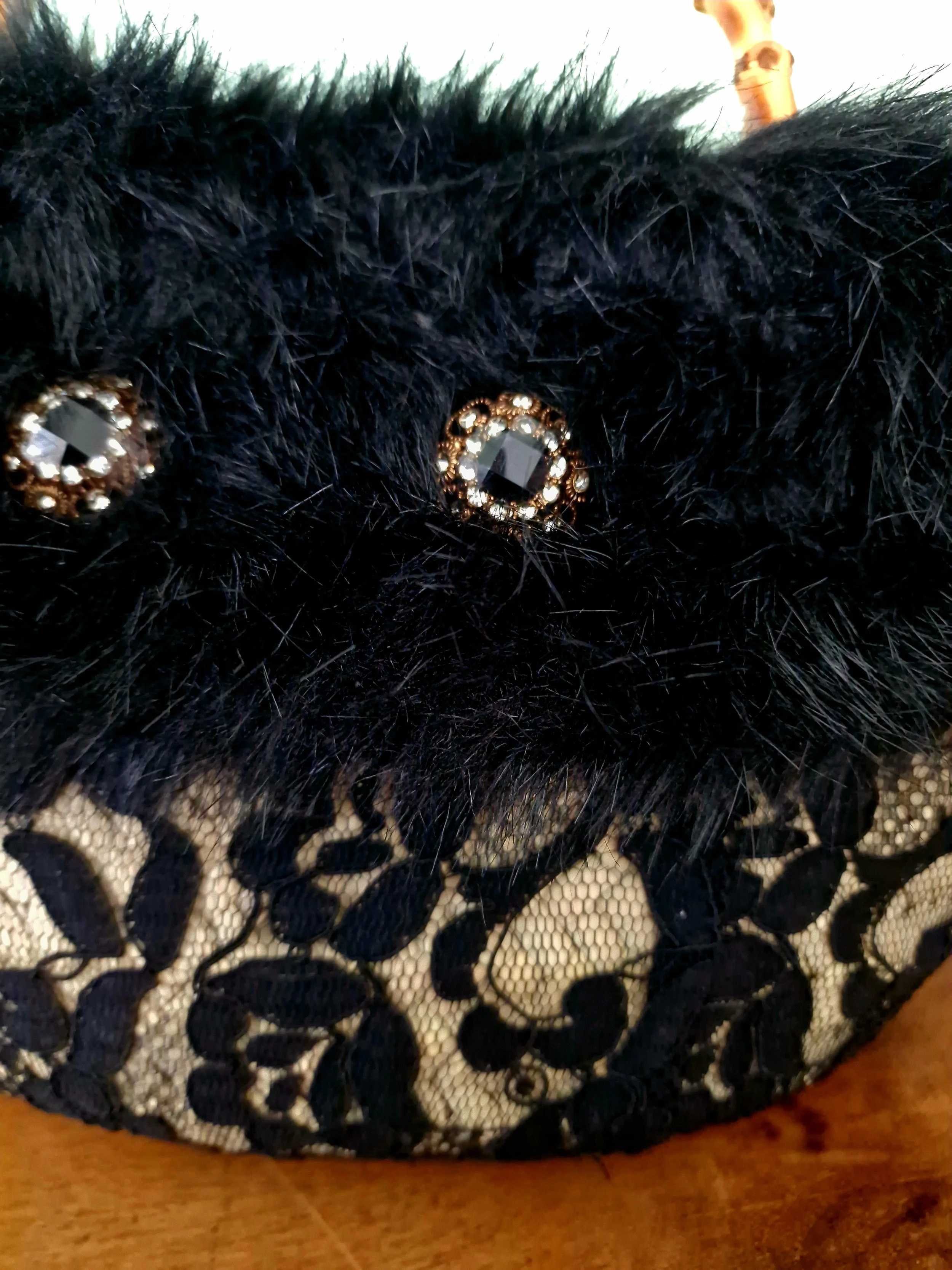 Dettaglio pizzo nero e pelliccia luxury della coffa “Notte d’Ammuri”, artigianato siciliano fatto a mano