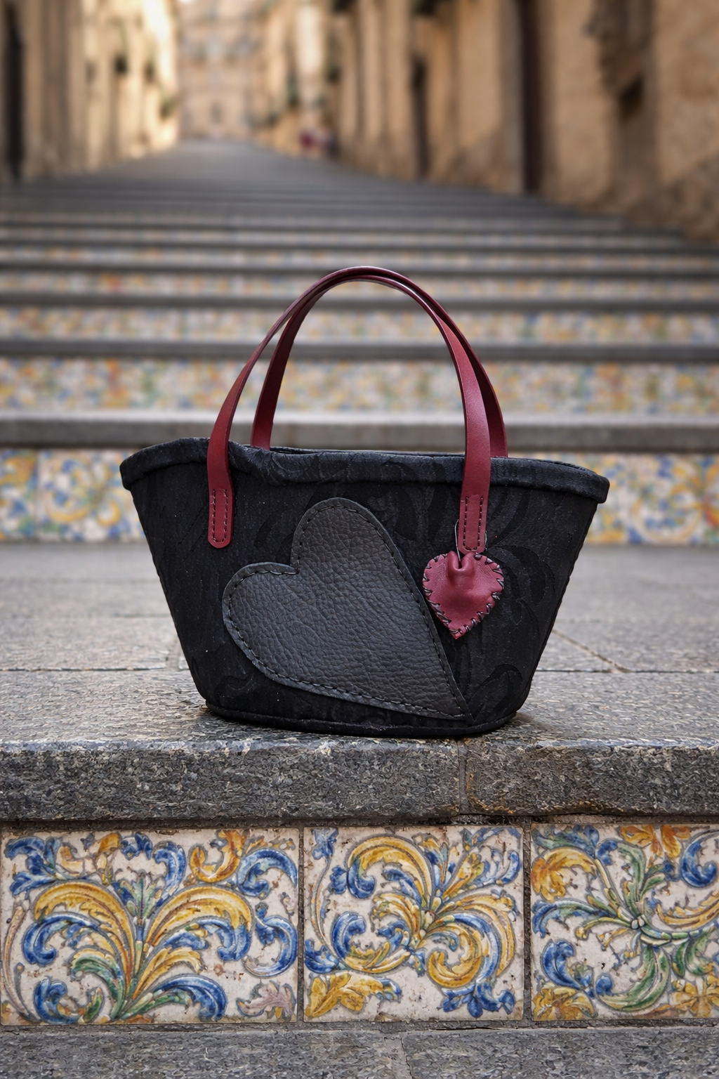 Dettaglio frontale della coffa Ammuri Caltagirone, realizzata a mano con materiali tessili e applicazioni in pelle.