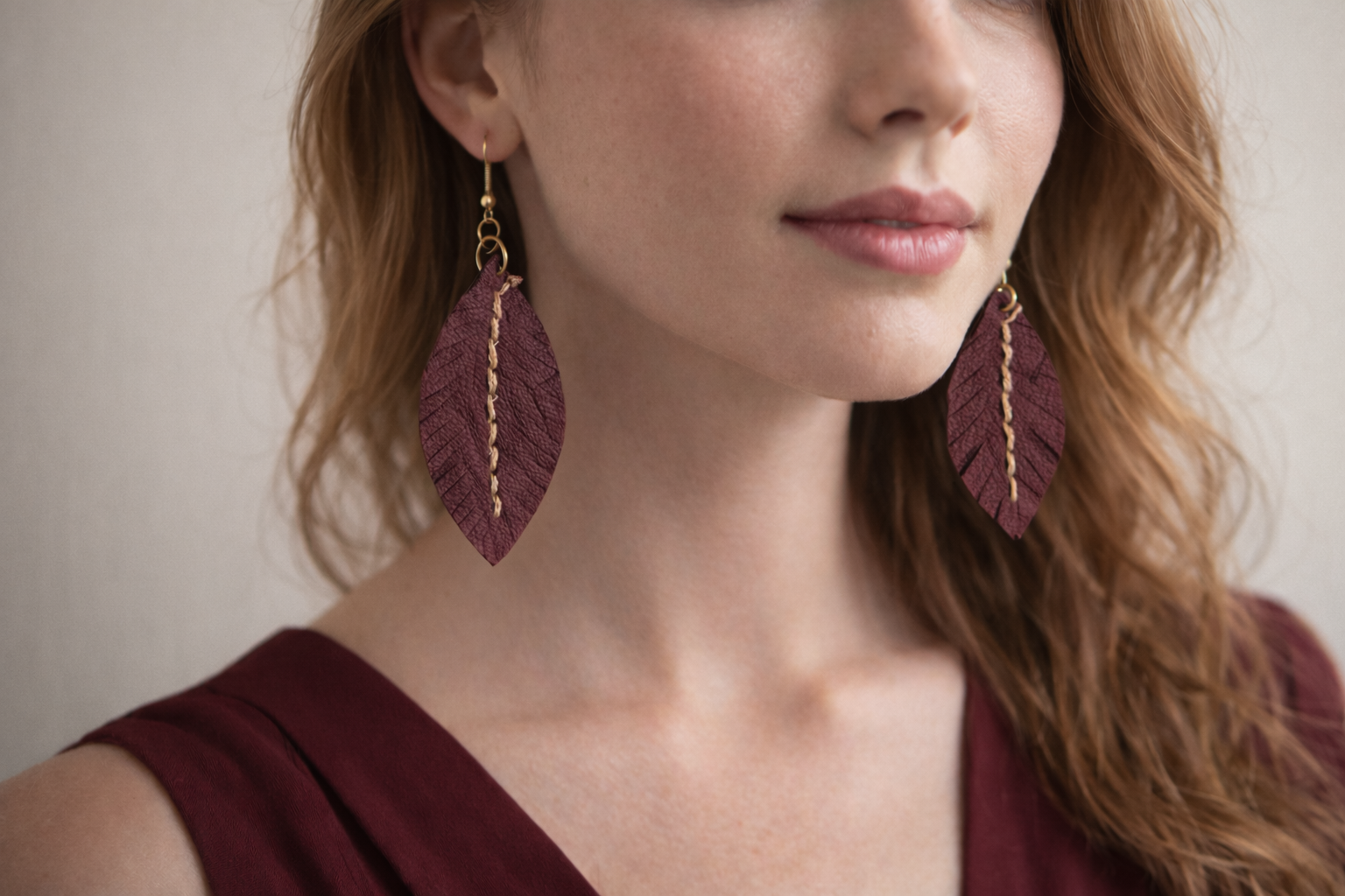 Orecchini Fronda in pelle bordeaux su modella, orecchini artigianali leggeri ed eleganti