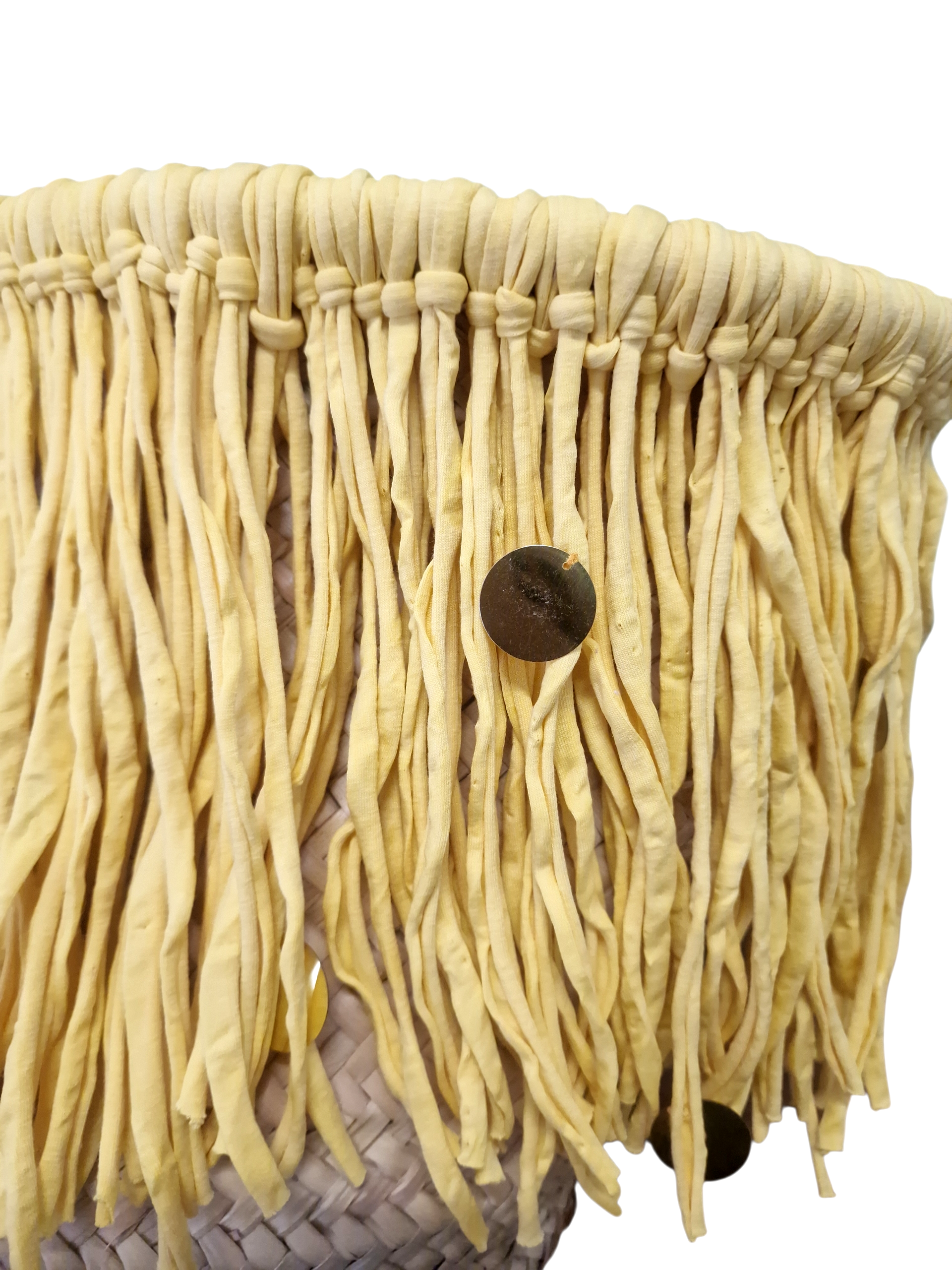 vista da vicino della frangia in cotone giallo pastello con paillette dorate