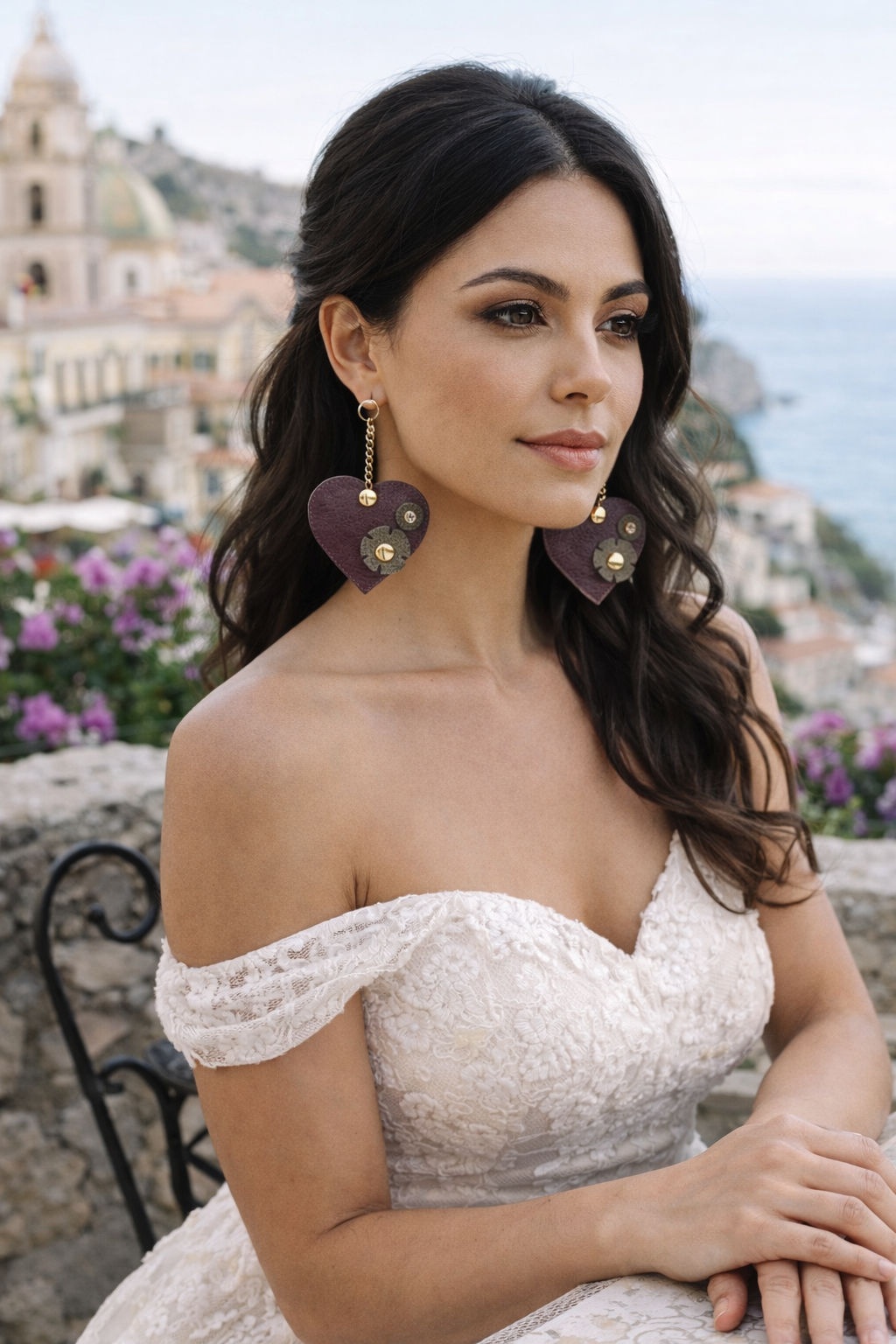 Orecchini artigianali a forma di cuore in pelle bordeaux con dettagli oro indossati da modella elegante in Sicilia