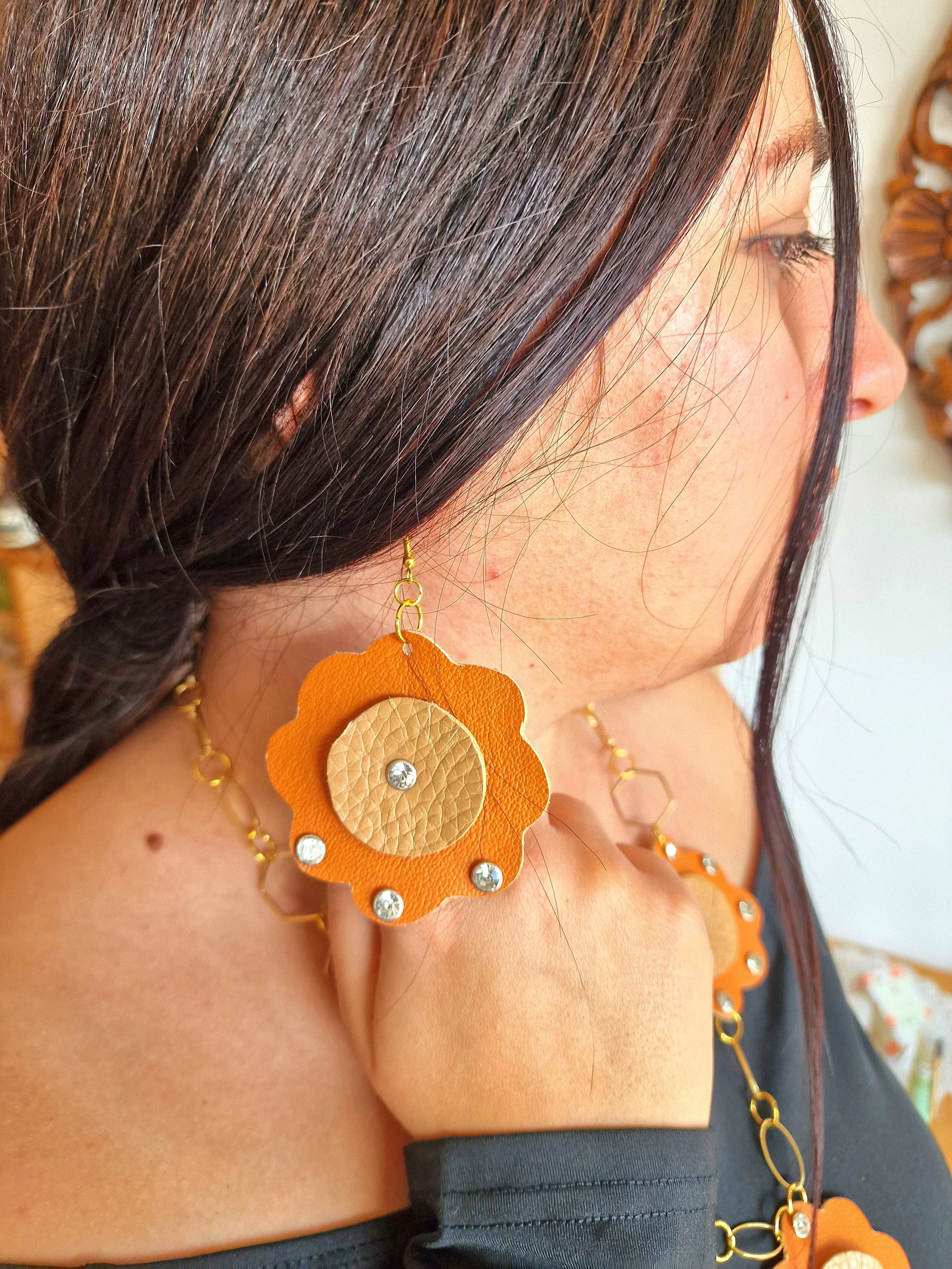 Orecchino artigianale in pelle a fiore con cristalli, collezione “Sole d’Ammuri”, dettaglio vicino al viso