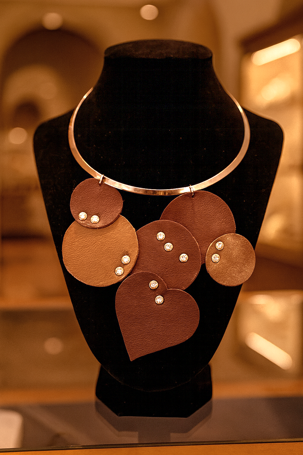 "Collana artigianale Ammuri con pendenti in pelle e dettagli luminosi, girocollo rigido color argento realizzato a mano in Sicilia"