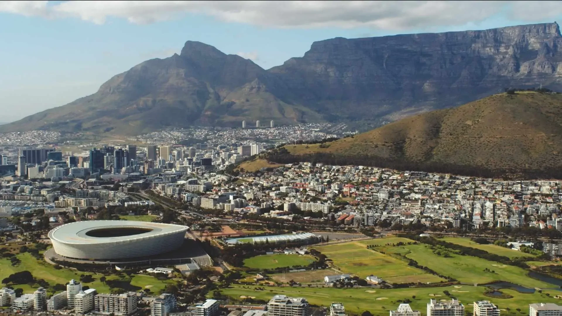 Cape Town aerial view — Aerial shot of Cape Town showing Table Mountain, Devil’s Peak, Green Point Stadium, and the Atlantic seaboard.