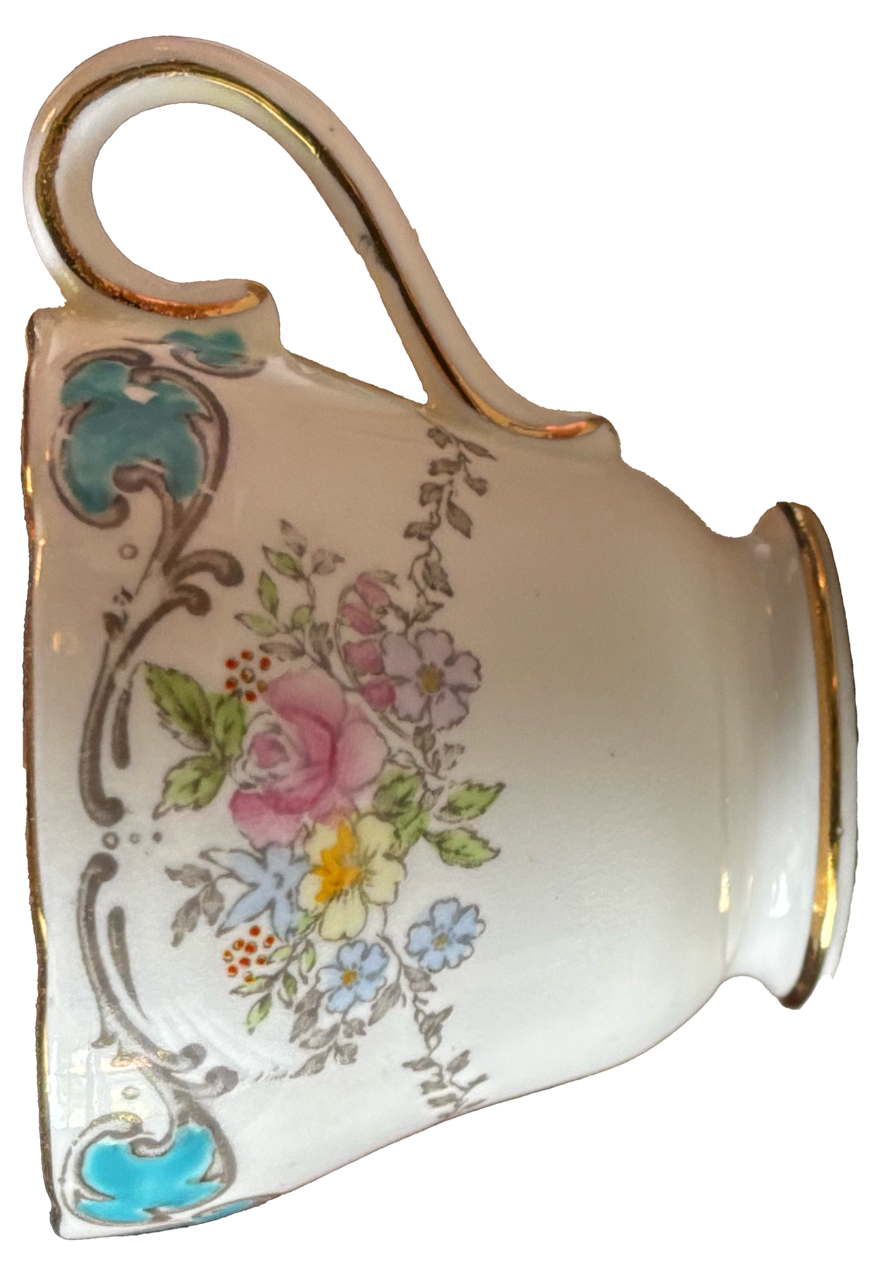 A decorative porcelain cup with floral patterns, gold trim, and a curved handle.