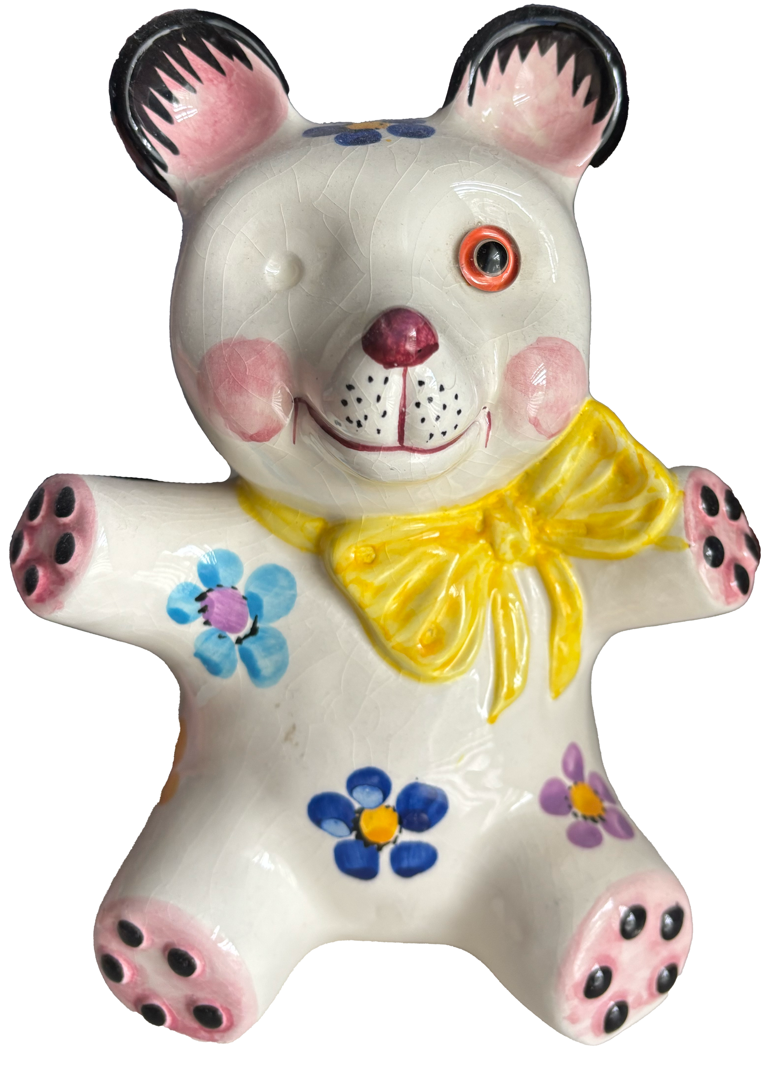 Ceramic teddy bear figurine with painted flowers, yellow neck bow, and one eye made of a button, with a pink nose and pink paw pads.