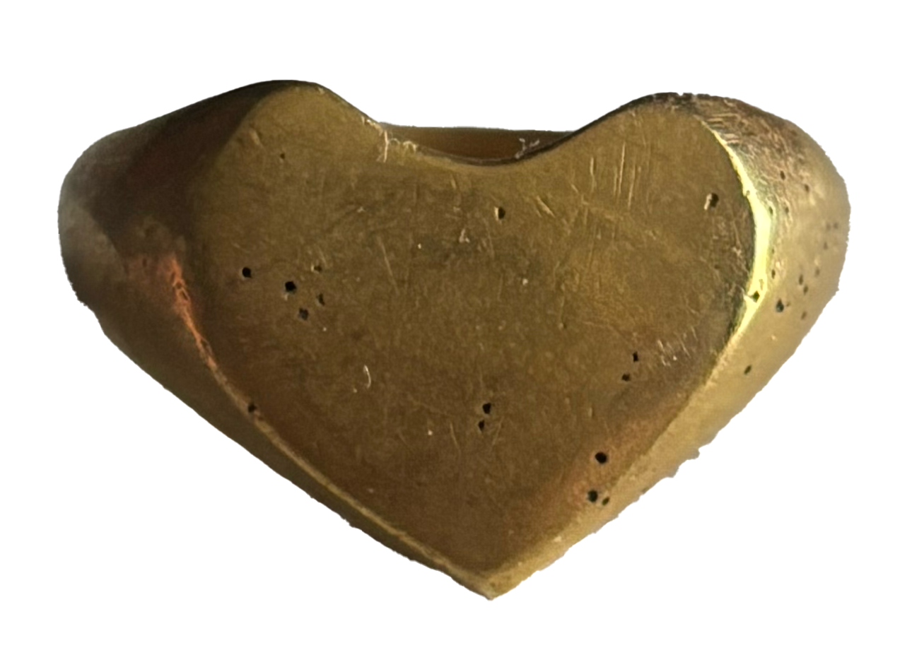 A heart-shaped brass or gold-colored object with small perforations.