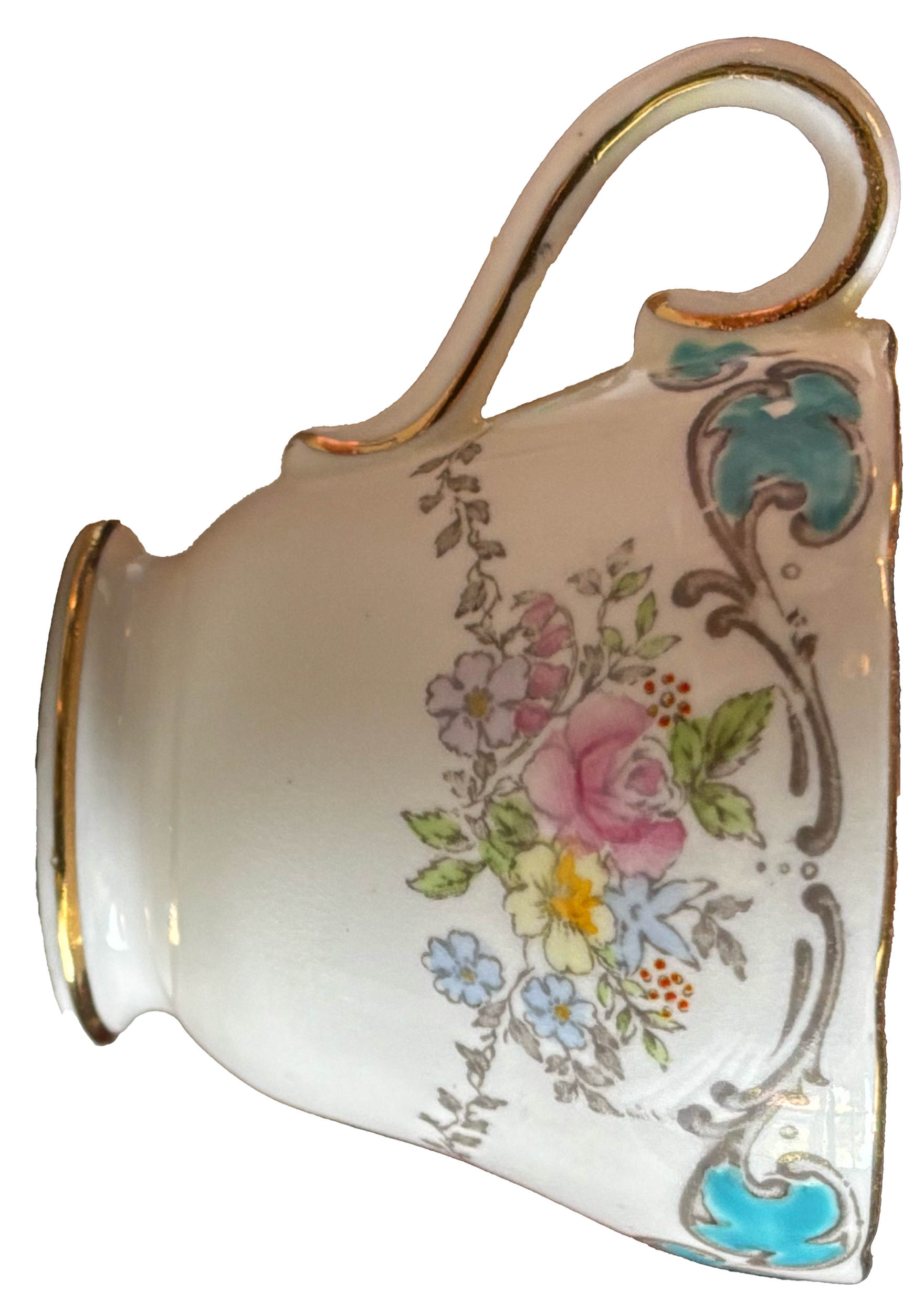 A ceramic mug with floral patterns and gold accents on the rim and handle, featuring pink, blue, and yellow flowers with green leaves.