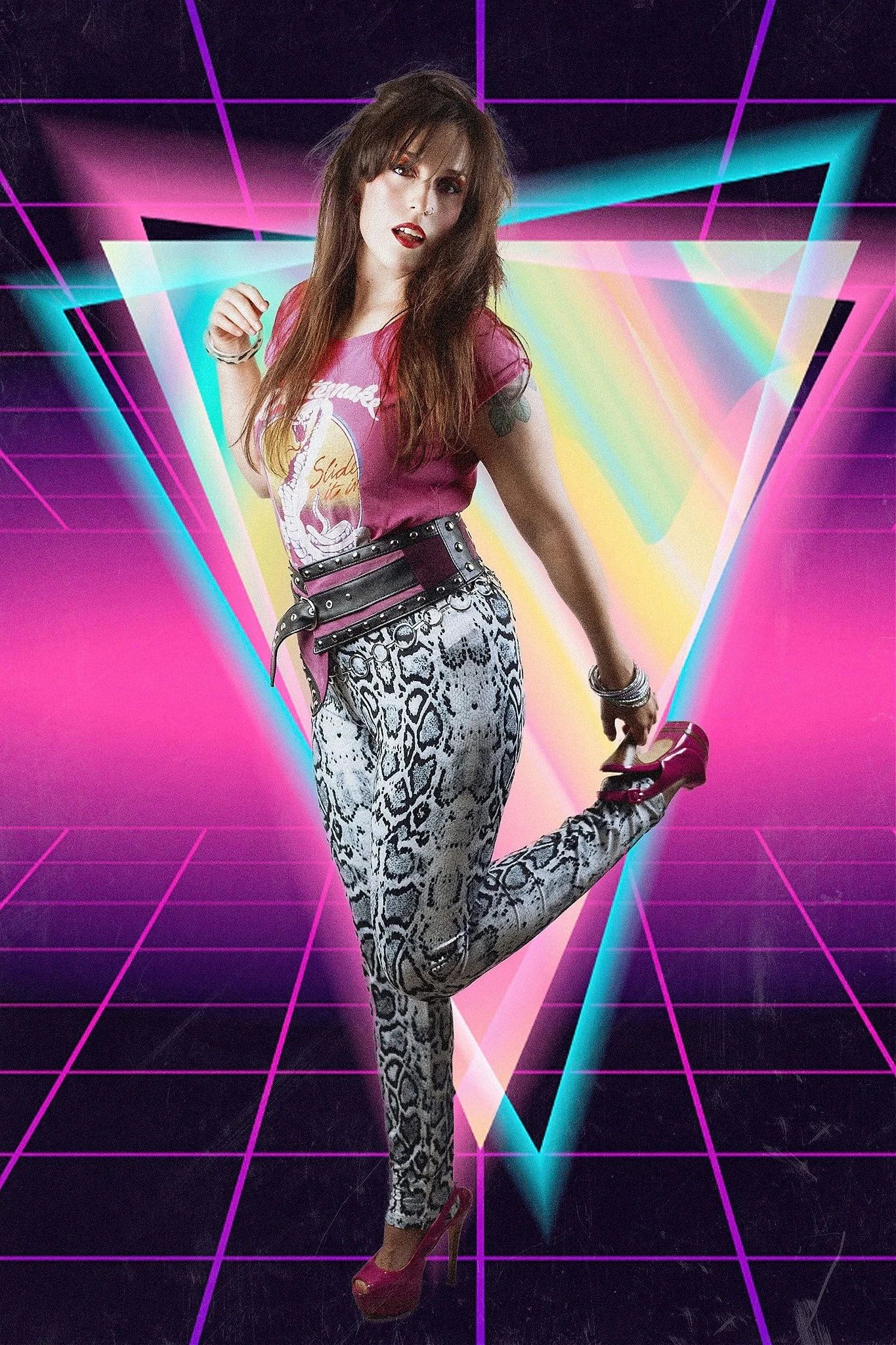 A woman with long brown hair, wearing a pink graphic t-shirt, black and white snake print pants, and pink high heels, is striking a pose in front of a colorful, neon, 80s style geometric background with pink, blue, and yellow hues.