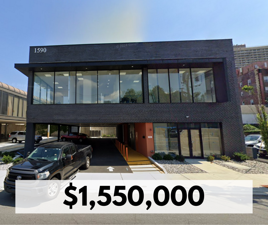 Modern black building with large glass windows, street view, parked cars, and an advertised price of $1,550,000.