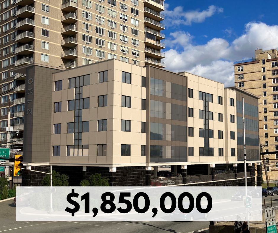 Modern multi-story building with beige and dark glass exterior, located at 21130, with other large buildings in the background, under a partly cloudy blue sky.