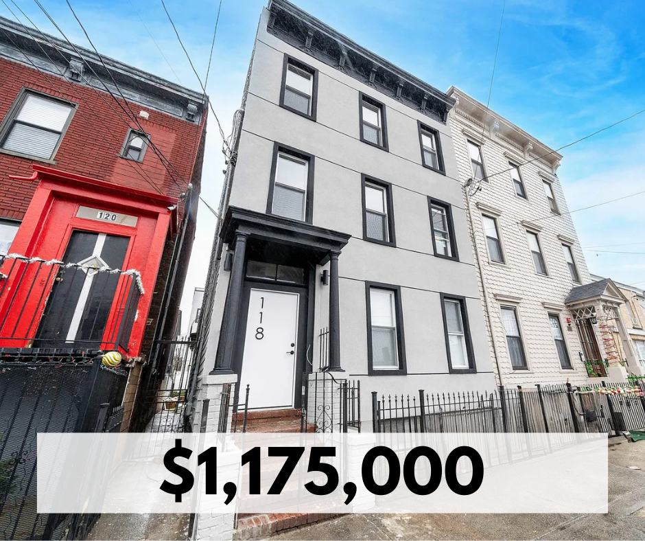 A row of three urban buildings with different architectural styles, including a white building with black window frames, a red building, and a light-colored building, under a bright blue sky.