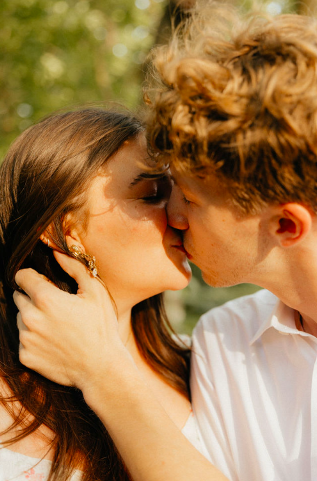 A couple kissing outdoors.