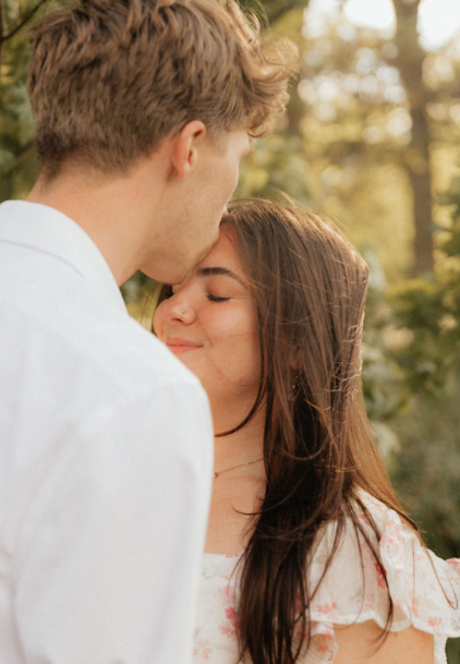 Young couple embracing outdoors with trees in the background