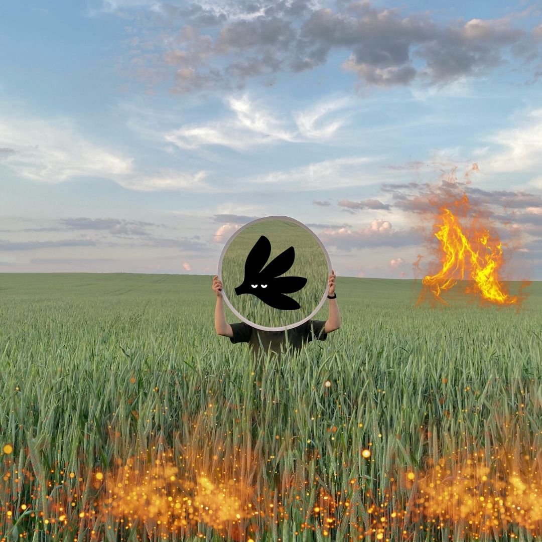 Person holding mirror with Our Kind Therapy cartoon logo figure standing in field with sparks of fire around 