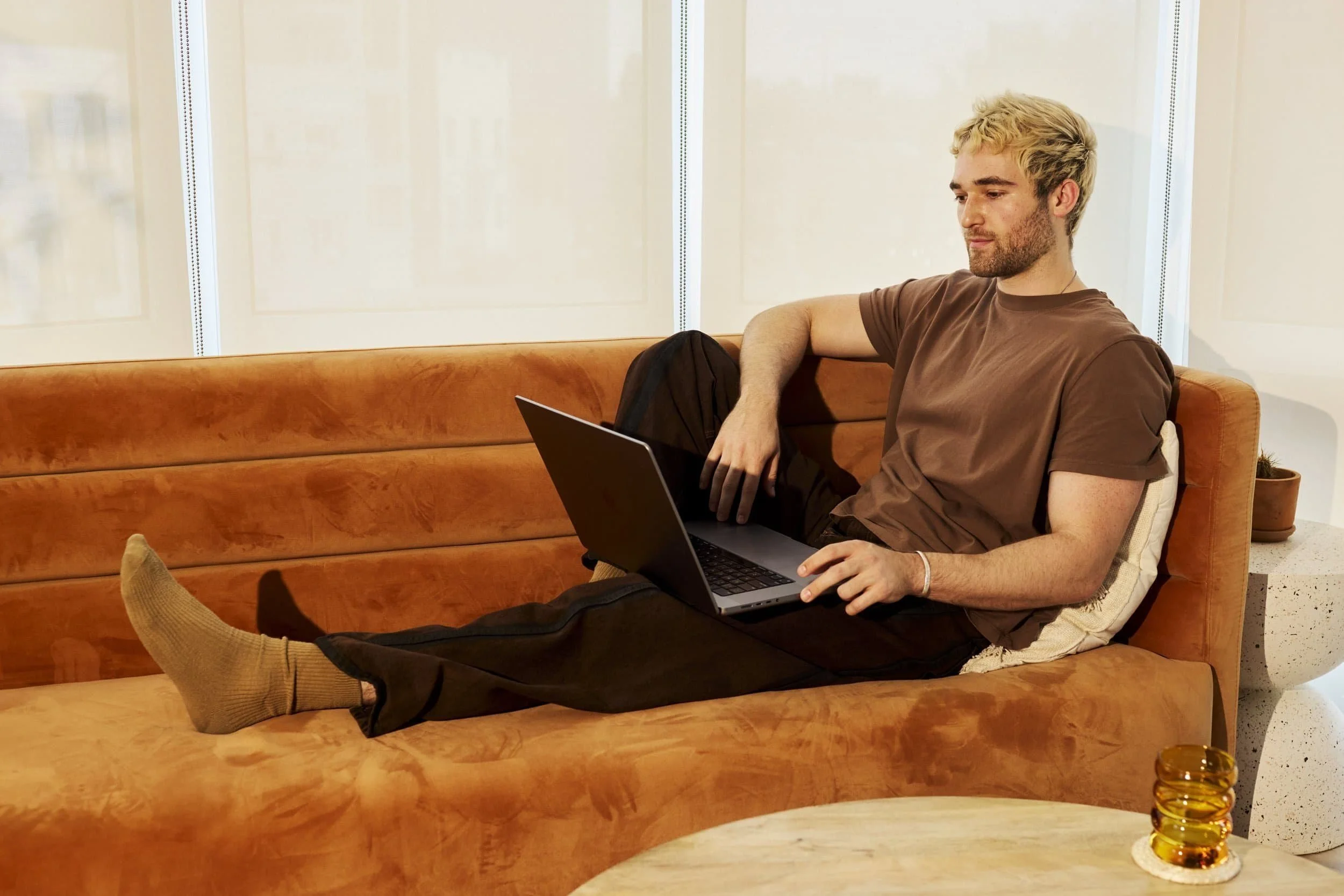 Man stretched out on couch completing online therapy.
