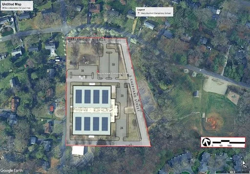 A satellite map showing a school with a playground, surrounded by trees and residential houses, with labeled streets and a legend for nearby Mount Carmel Cemetery School.