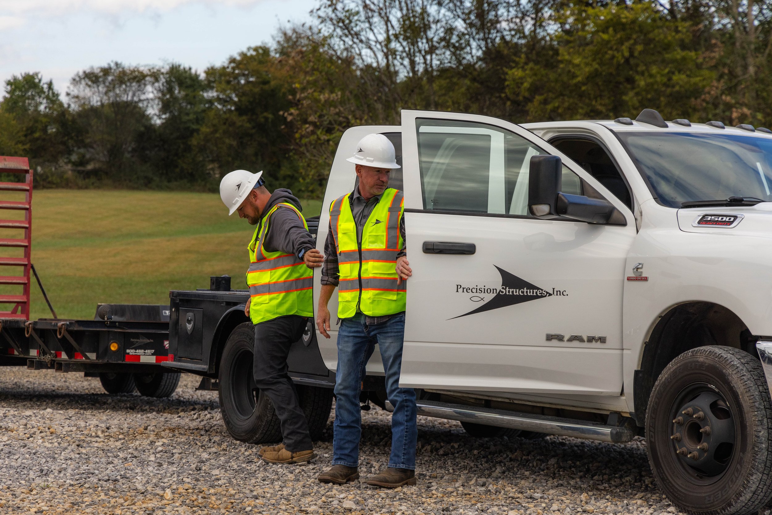 Precision Structures, Inc. crew arriving on-site for a roofing restoration project in East Tennessee, stepping out of branded trucks ready to rebuild.