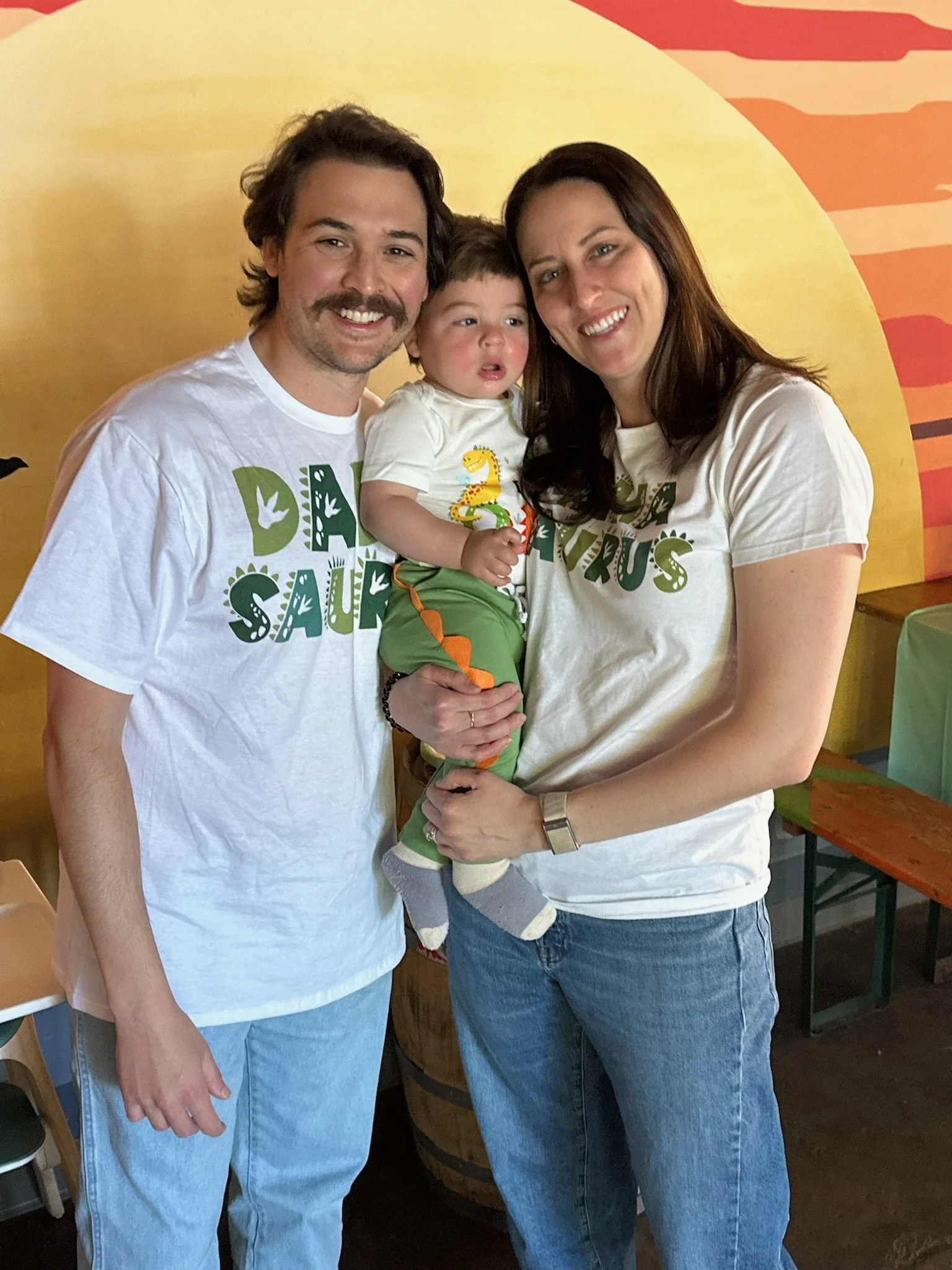 Parents with their baby at his "One-a-Saurus" birthday party
