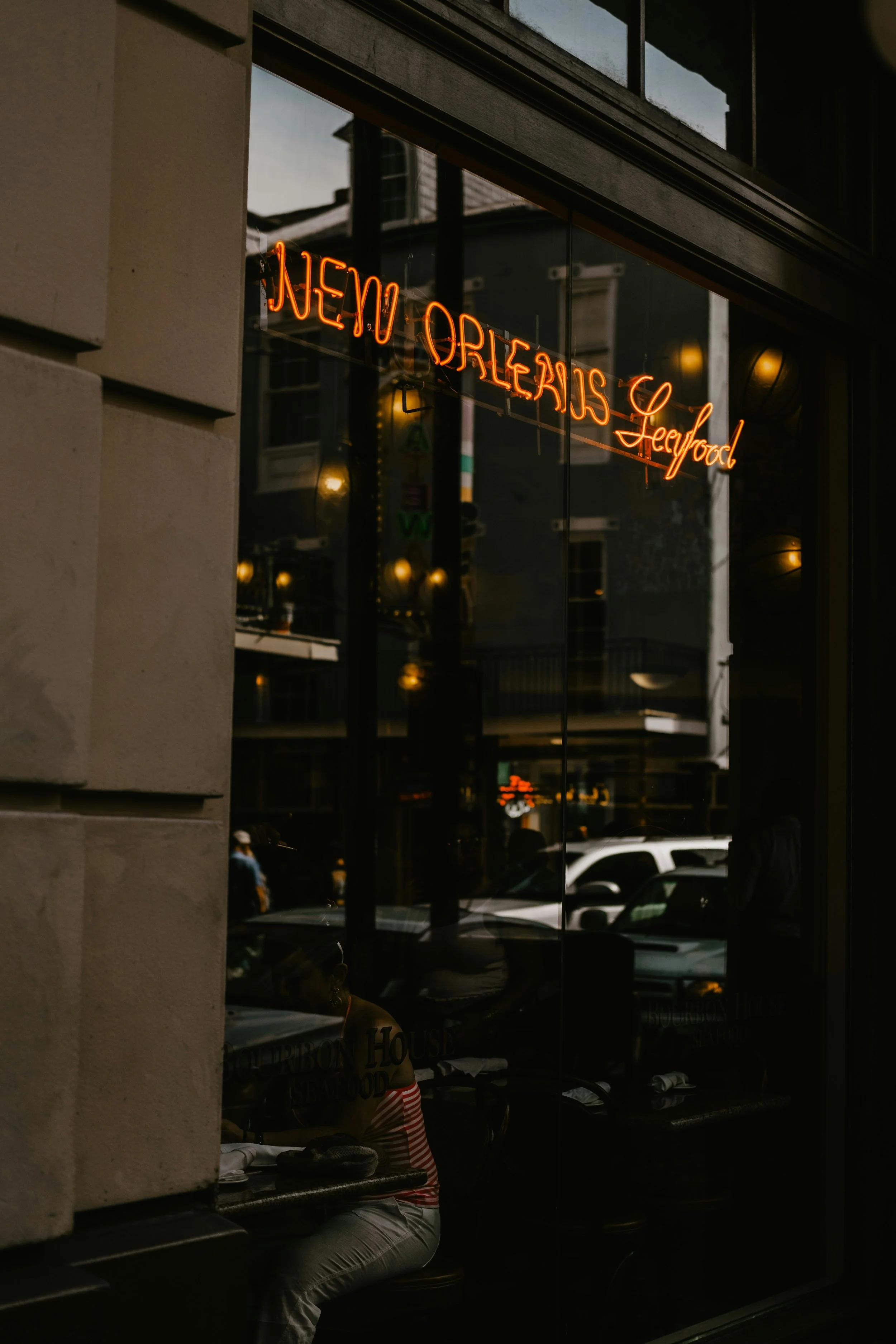 Neon sign in window advertising seafood at a restaurant in New Orleans.
