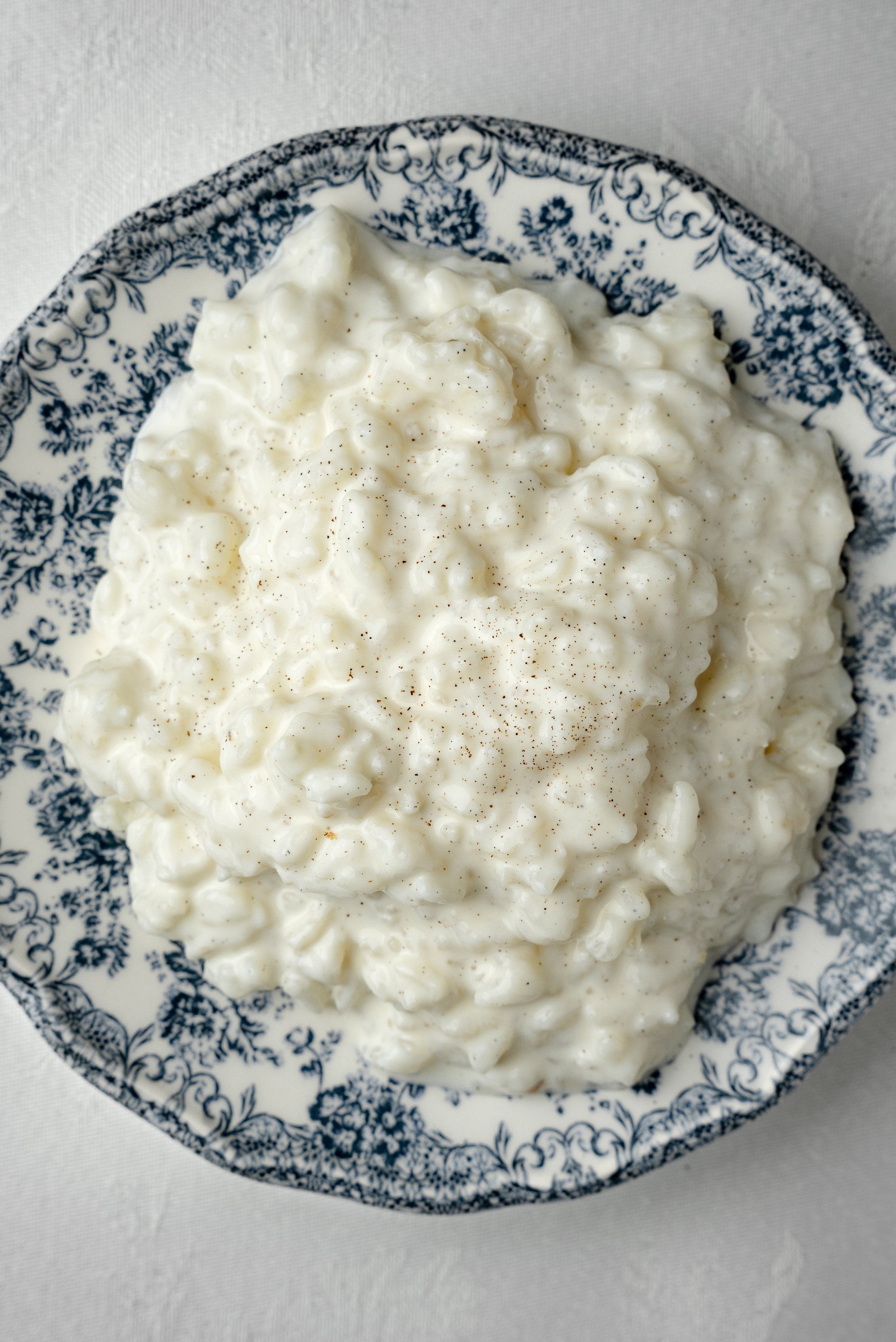 Riz au lait dans un bol blanc avec un motif floral bleu.