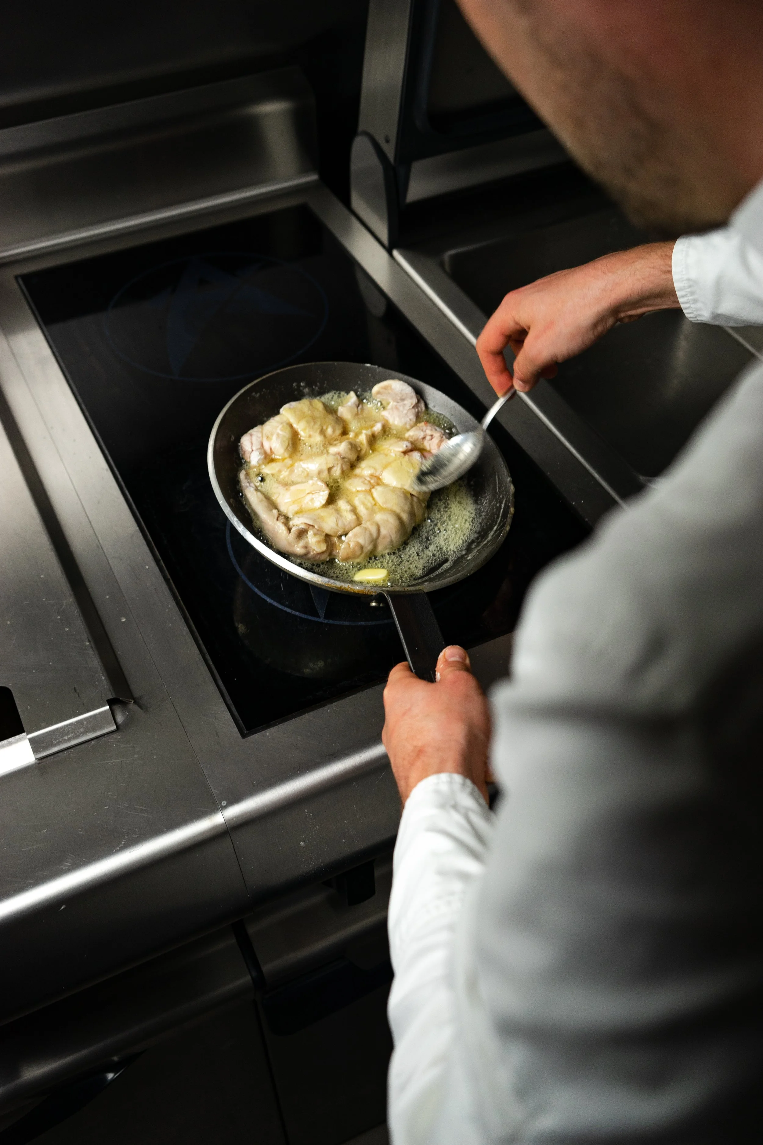Un chef cuisine des sandwichs dans une poêle sur une plaque de cuisson électrique.