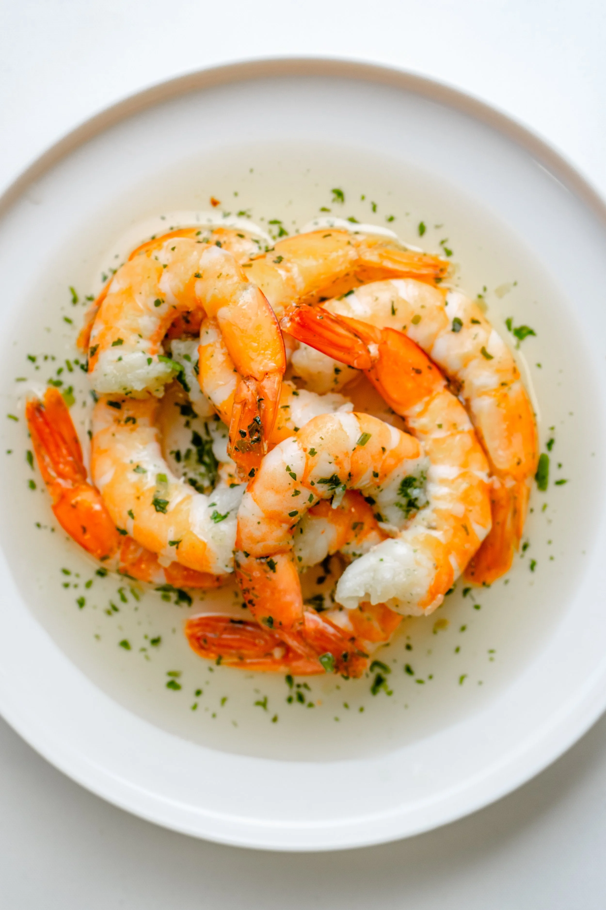 Crevettes décortiquées dans une sauce blanche garnie de persil