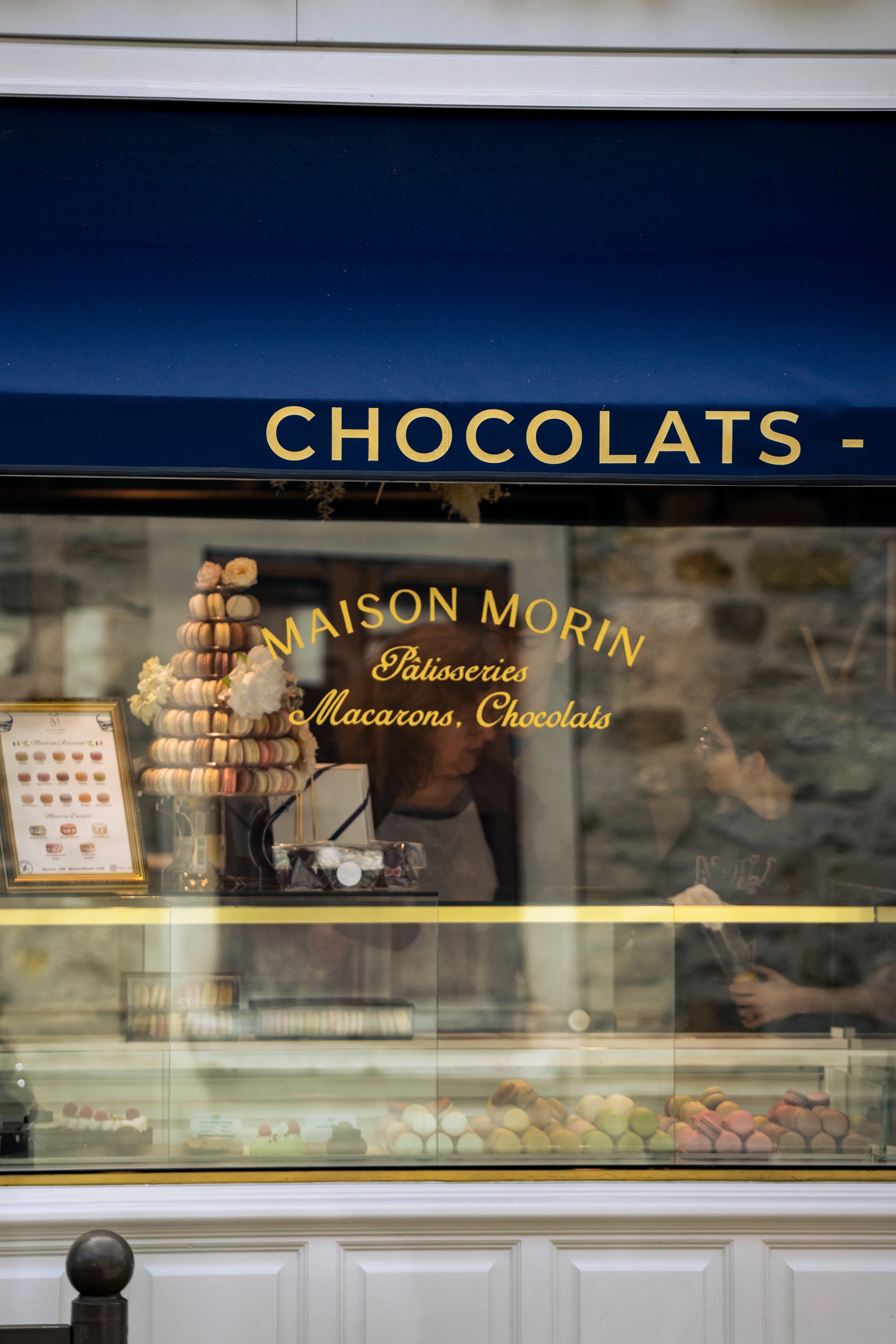 Vitrine d'une boutique de chocolats et macarons portant l'inscription « MAISON MORIN Pâtisseries Macarons, Chocolat »
