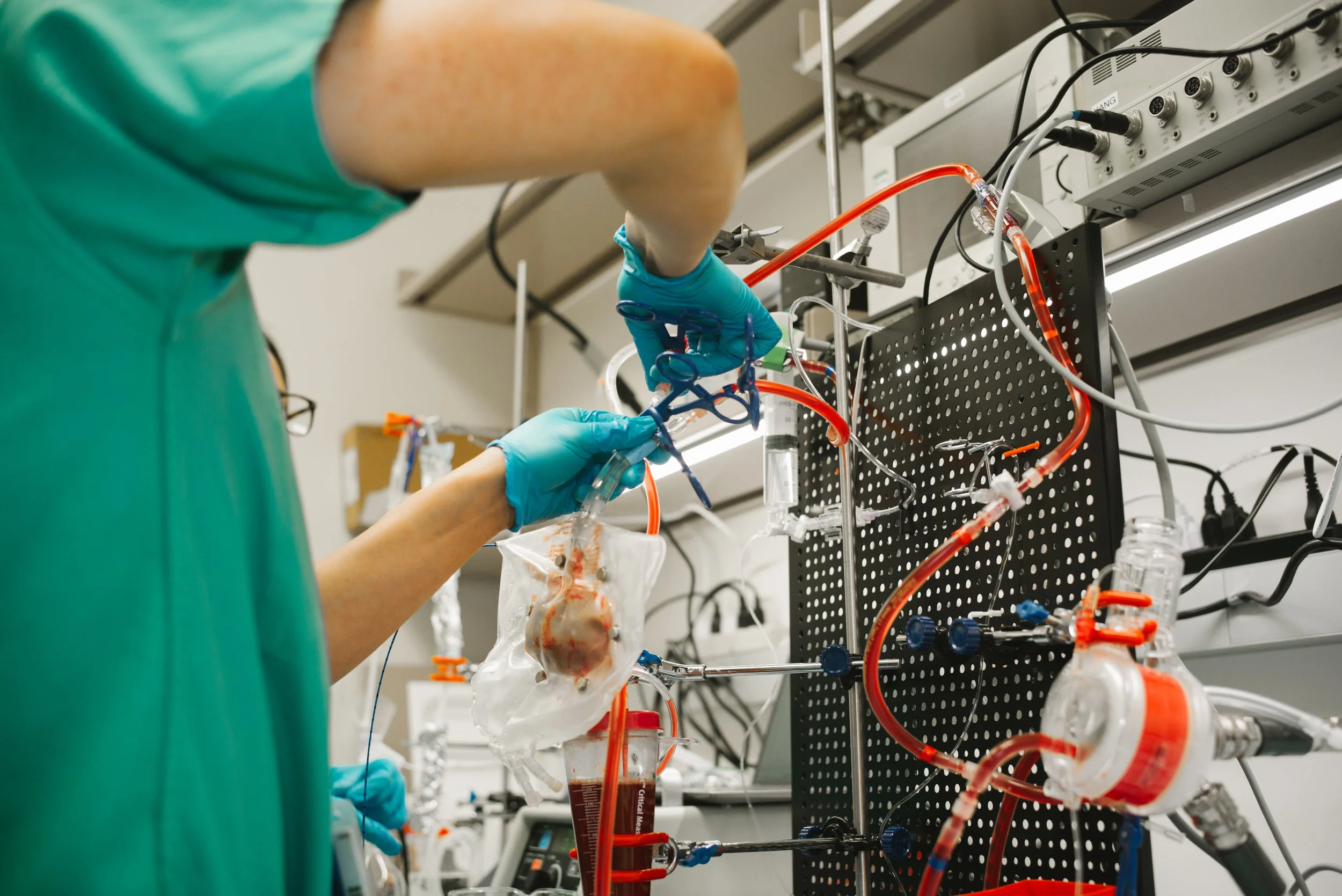 A scientist working with laboratory equipment, tubes, and pipelines in a laboratory setting.