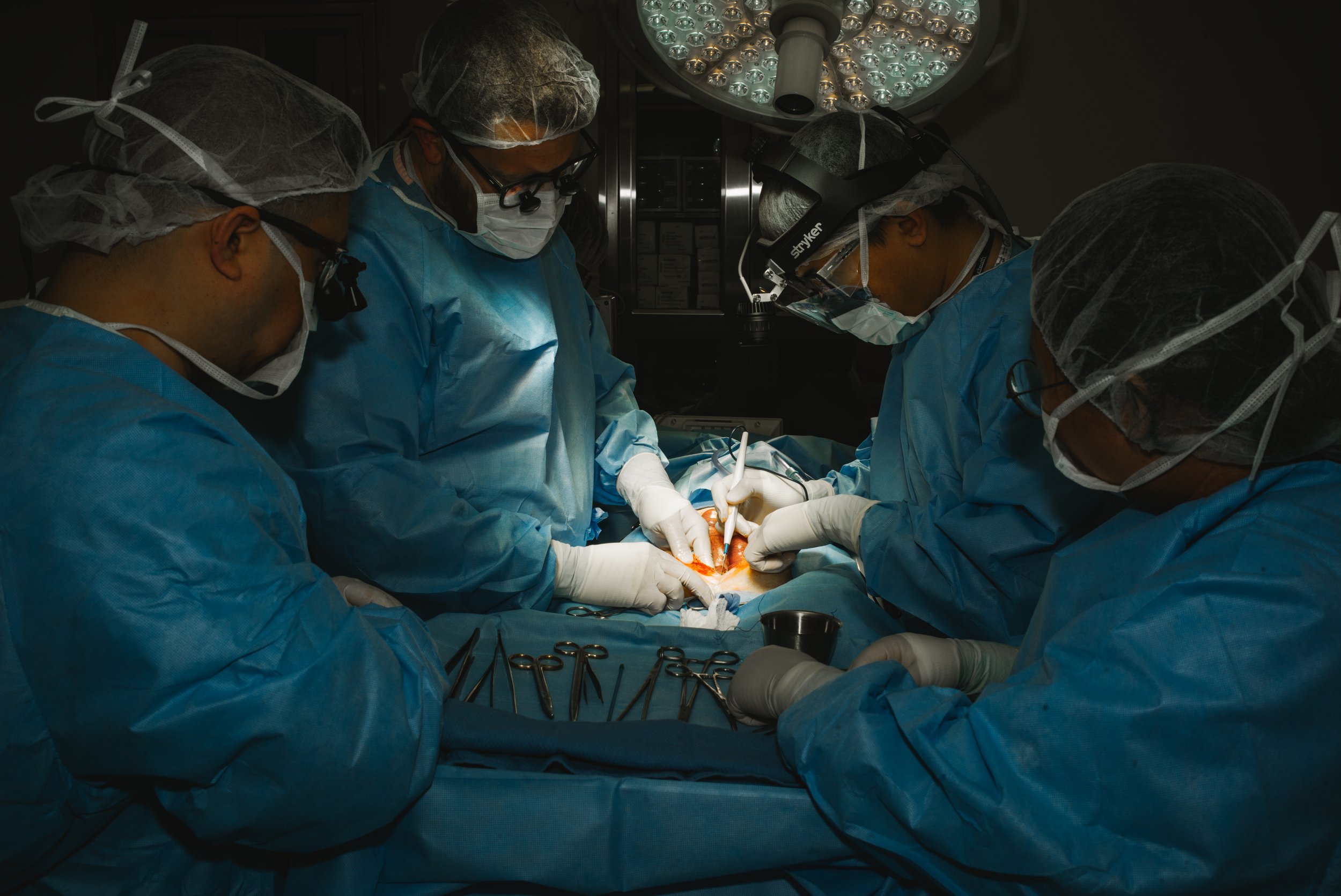 Group of surgeons performing an operation in an operating room.