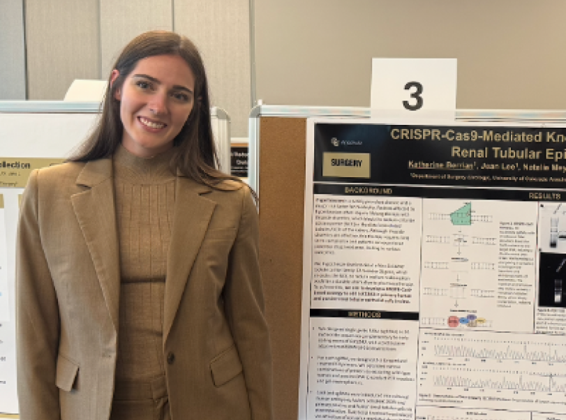 Young woman standing next to a research poster presentation at an academic conference.