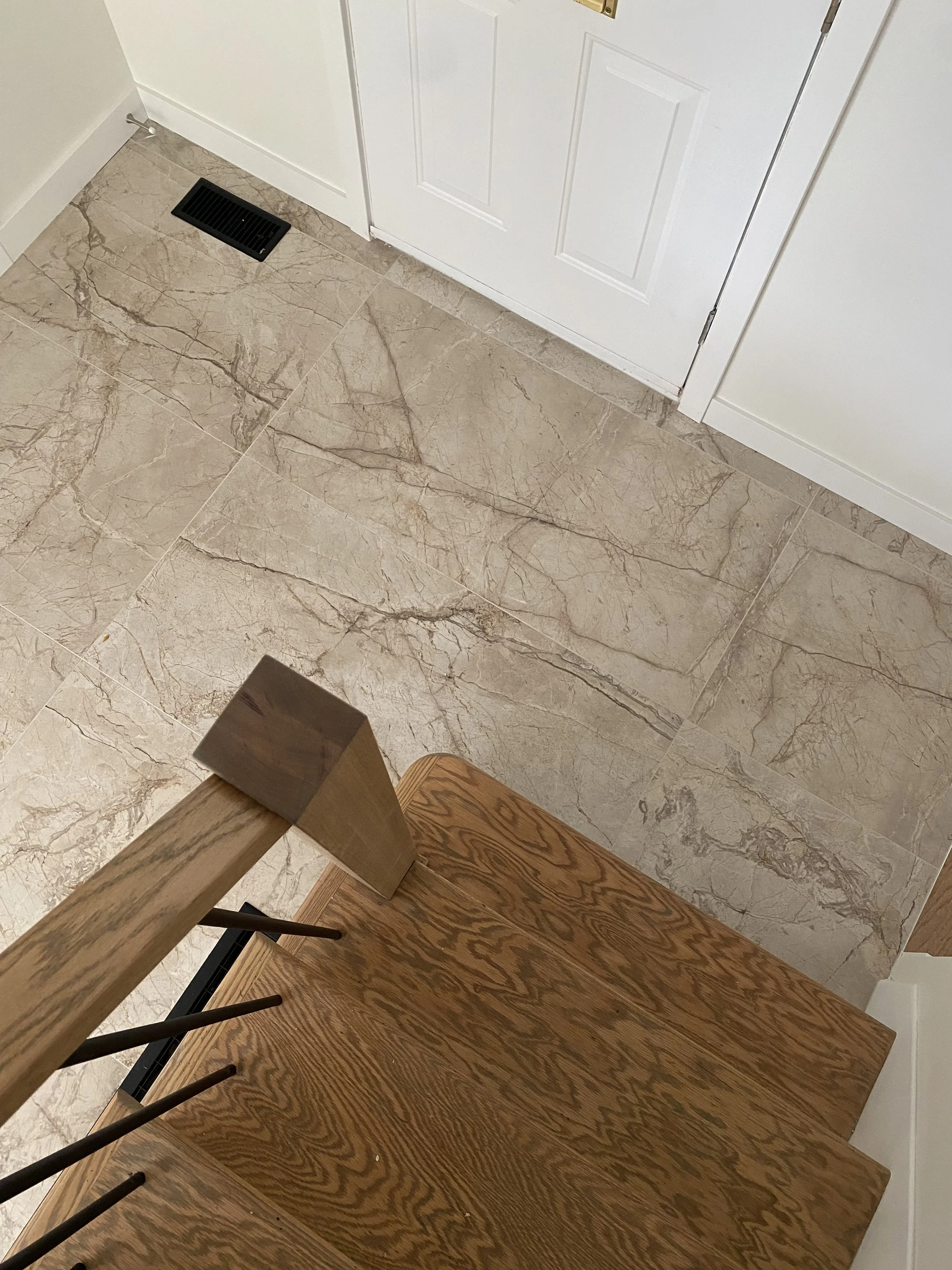 Modern bathroom with double vanity, large mirrors, beige cabinet, gold fixtures, and a glass-enclosed shower