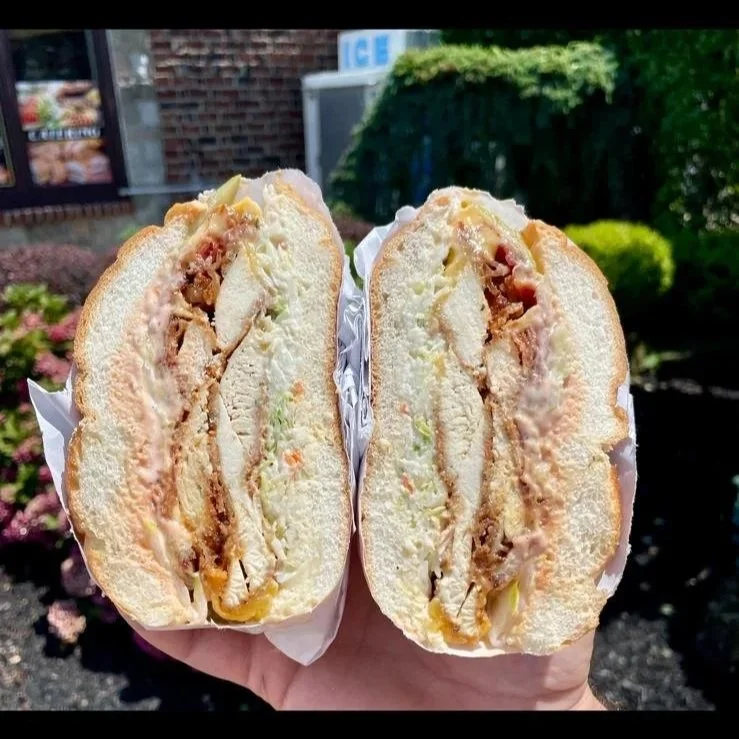 Half of a chicken salad sandwich, showing lettuce, chicken, and sauce inside a bun