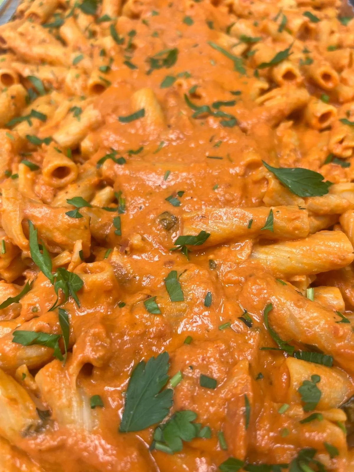 Close-up of pasta with tomato sauce and fresh herbs.