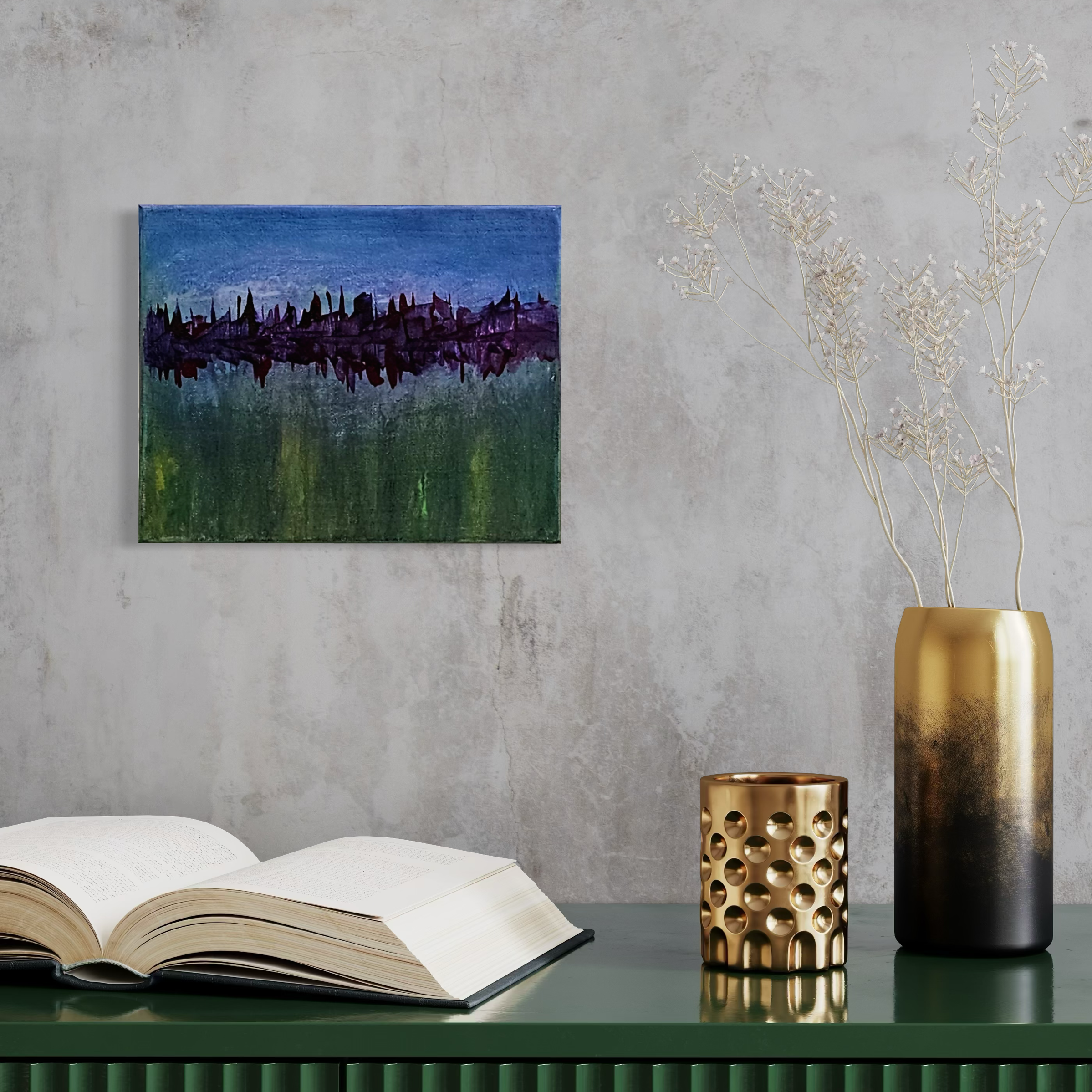 Interior scene with an open book on a dark green sideboard, a tall gold and black vase with white dried branches, a smaller gold decorative object with circular cutouts, and a colorful landscape painting on a concrete wall.