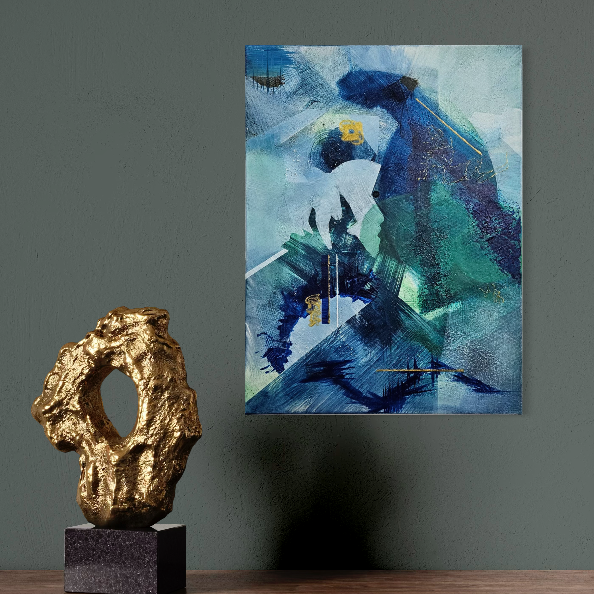 A blue and green abstract painting hung on a grey wall, with a gold-textured sculpture on a black pedestal in front of it.