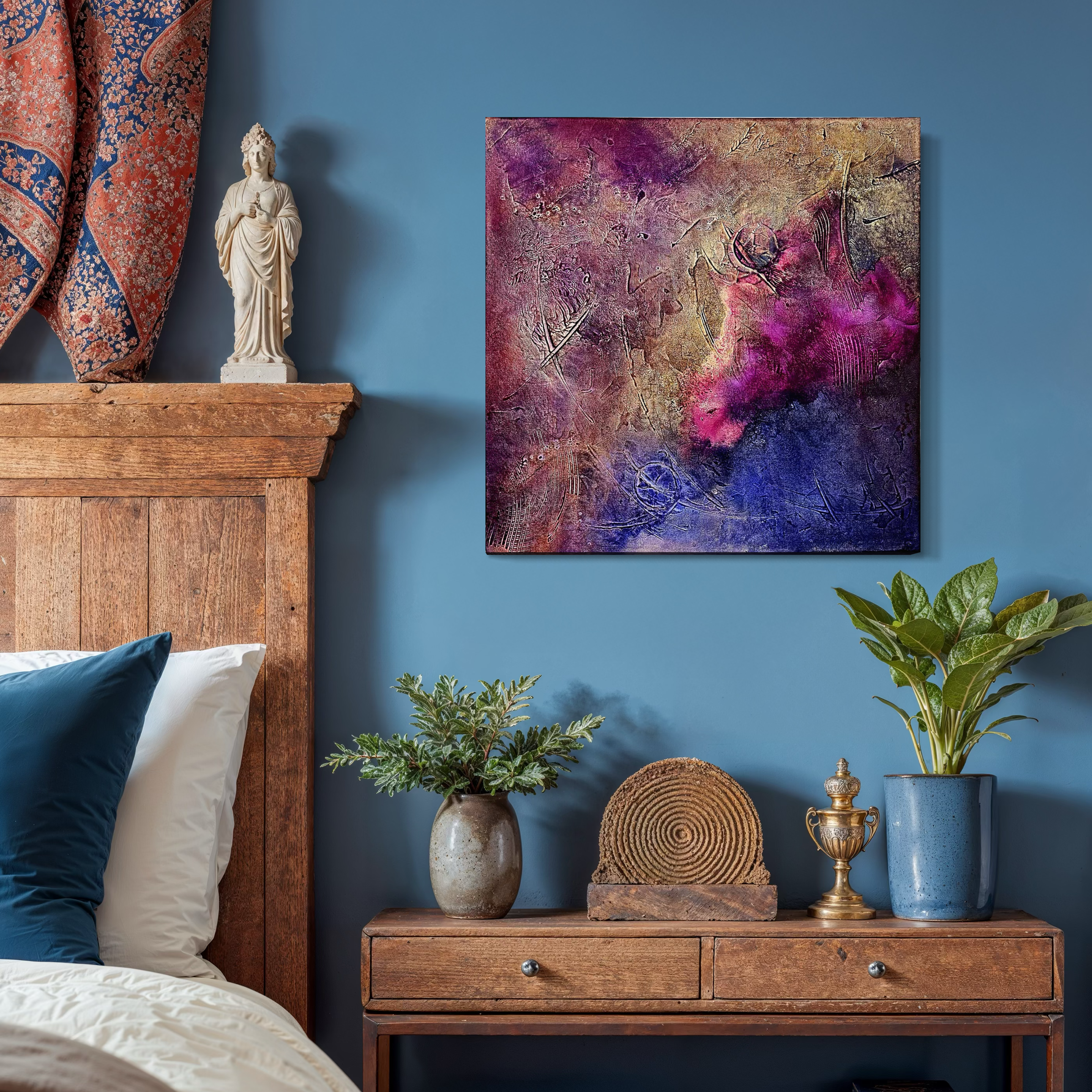 Decorative bedroom corner with a blue wall, abstract colorful painting, wooden headboard, drawer with potted plants, a wooden sculpture, and a small golden vase.