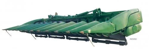 Green agricultural implement, possibly a disc mower or a harrow, used for farming or soil preparation.